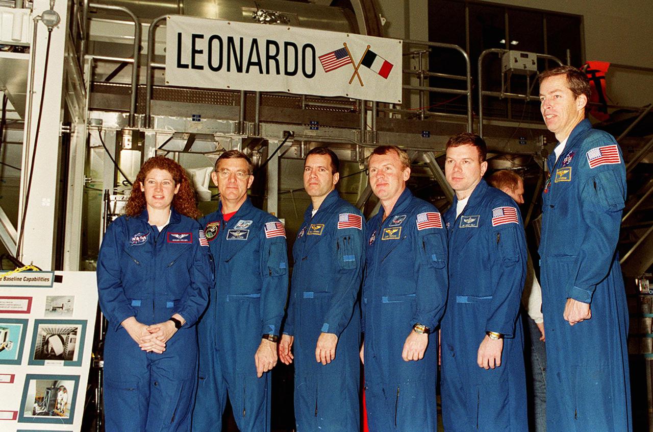 KENNEDY SPACE CENTER, FLA. -- The crew of STS-102, plus Expedition Two astronauts, poses in front of Leonardo, the Multi-Purpose Logistics Module that will fly on the mission. From left are Susan Helms and James Voss, part of Expedition Two; Mission Specialists Paul W. Richards and Andrew S.W. Thomas; Pilot James M. Kelly; and Commander James D. Wetherbee. Not shown is cosmonaut Yuri Usachev, who is also part of Expedition Two. The MPLM is the first of three such pressurized modules that will serve as the International Space Station’s “moving vans,” carrying laboratory racks filled with equipment, experiments and supplies to and from the Space Station aboard the Space Shuttle. Leonardo will be launched March 1, 2001, on Shuttle mission STS-102. On that flight, Leonardo will be filled with equipment and supplies to outfit the U.S. laboratory module Destiny. The mission will also be carrying the Expedition Two crew to the Space Station, replacing the Expedition One crew who will return on Shuttle Discovery
