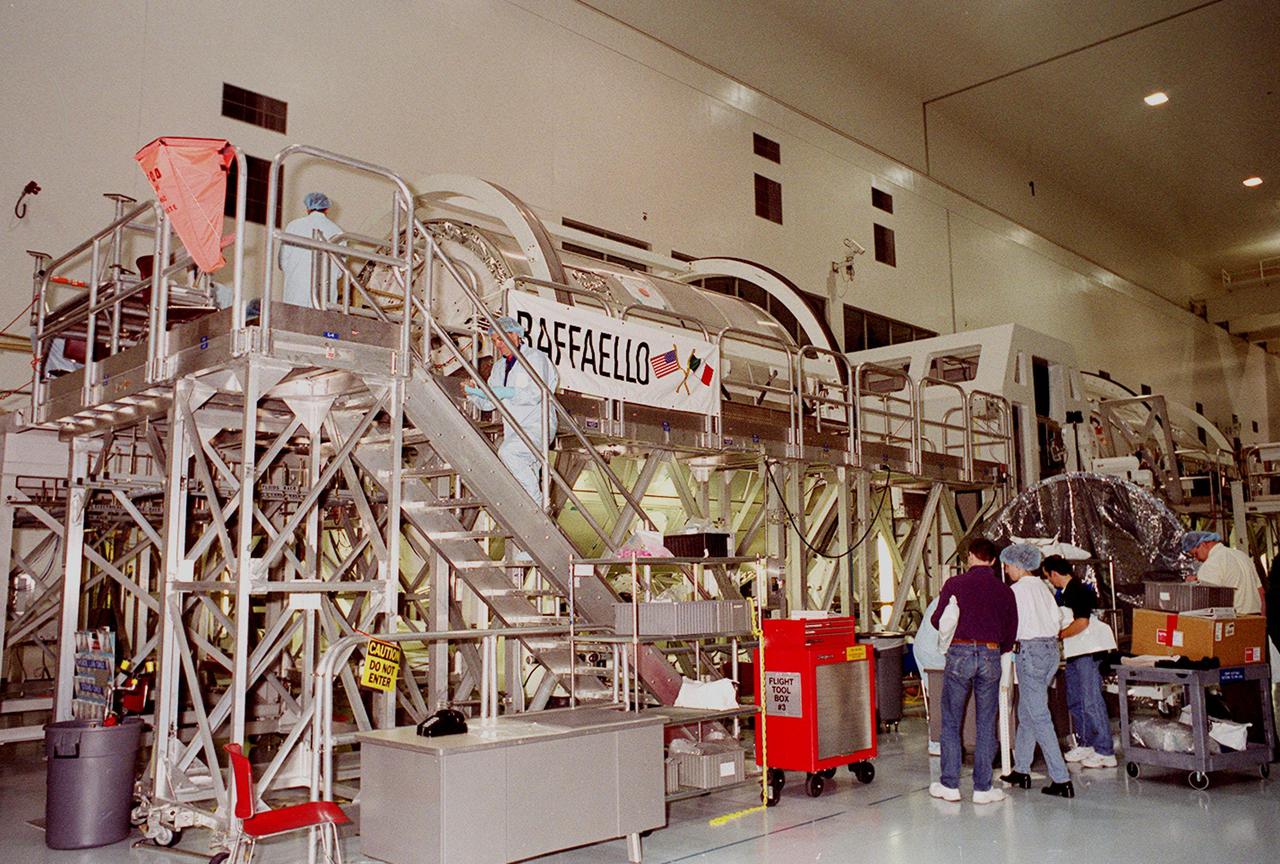 KENNEDY SPACE CENTER, FLA. -- In the Space Station Processing Facility, Multi-Purpose Logistics Module Leonardo has the attention of workers and some of the STS-102 crew. The MPLM, part of the payload on the STS-102 mission, is the first of three pressurized modules that will serve as the International Space Station’s “moving vans,” carrying laboratory racks filled with equipment, experiments and supplies to and from the Space Station aboard the Space Shuttle. Leonardo is scheduled to be launched in early March. On that flight, Leonardo will be filled with equipment and supplies to outfit the U.S. laboratory module Destiny. The mission will also be carrying the Expedition Two crew to the Space Station, replacing the Expedition One crew who will return on Shuttle Discovery