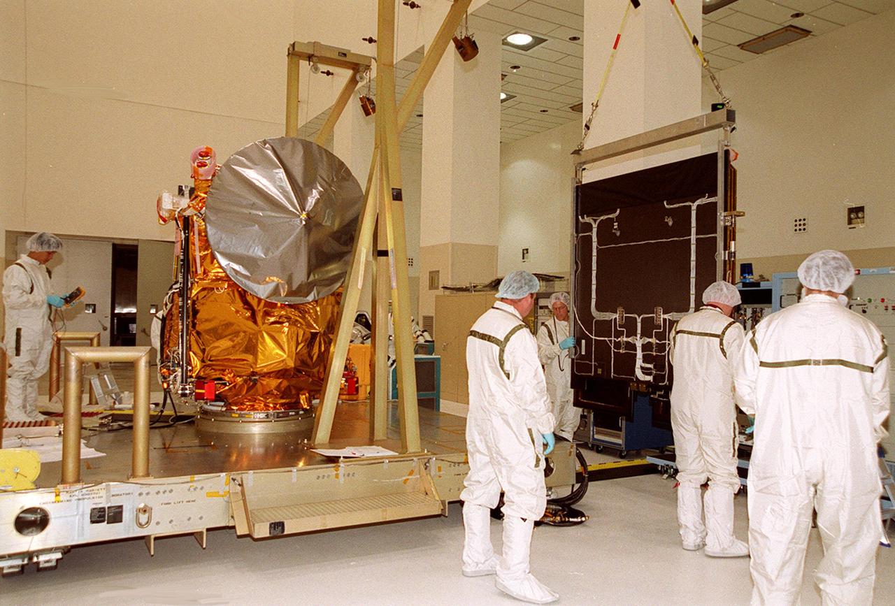 In the Spacecraft Assembly and Encapsulation Facility -2, the solar array from the 2001 Mars Odyssey Orbiter is moved toward a workstand. This will give workers access to other components of the spacecraft and allow inspection of the array. The Mars Odyssey carries three science instruments: the Thermal Emission Imaging System (THEMIS), the Gamma Ray Spectrometer (GRS), and the Mars Radiation Environment Experiment (MARIE). THEMIS will map the mineralogy and morphology of the Martian surface using a high-resolution camera and a thermal infrared imaging spectrometer. The GRS will achieve global mapping of the elemental composition of the surface and determine the abundance of hydrogen in the shallow subsurface. [The GRS is a rebuild of the instrument lost with the Mars Observer mission.] The MARIE will characterize aspects of the near-space radiation environment as related to the radiation-related risk to human explorers. The Mars Odyssey Orbiter is scheduled for launch on April 7, 2001, aboard a Delta 7925 rocket from Launch Pad 17-A, Cape Canaveral Air Force Station