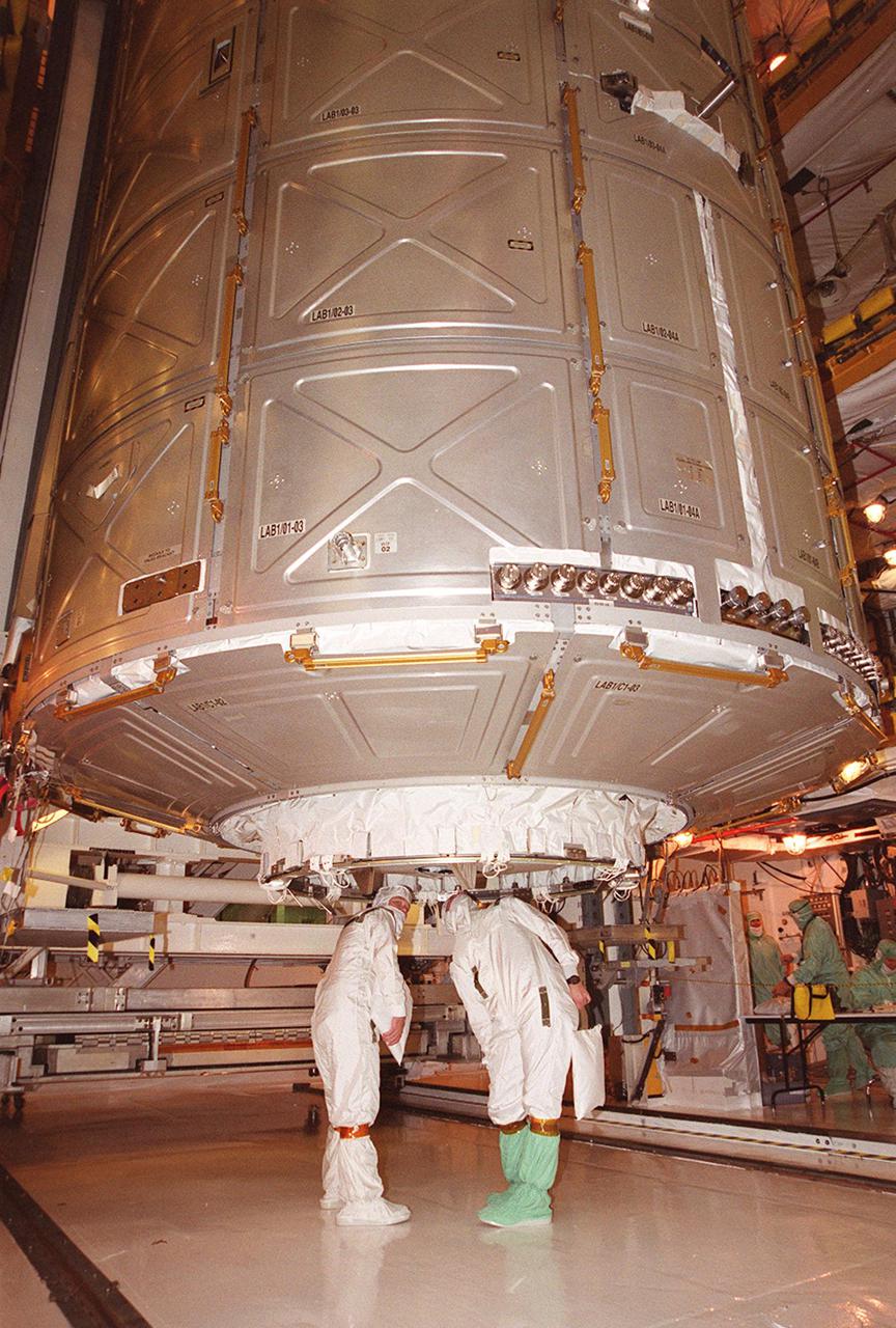 Workers in the Payload Changeout Room check the U.S. Lab Destiny as its moves from Atlantis’ payload bay into the PCR. Destiny will remain in the PCR while Atlantis rolls back to the Vehicle Assembly Building to allow workers to conduct inspections, continuity checks and X-ray analysis on the 36 solid rocket booster cables located inside each booster’s system tunnel. An extensive evaluation of NASA’s SRB cable inventory revealed conductor damage in four (of about 200) cables on the shelf. Shuttle managers decided to prove the integrity of the system tunnel cables already on Atlantis
