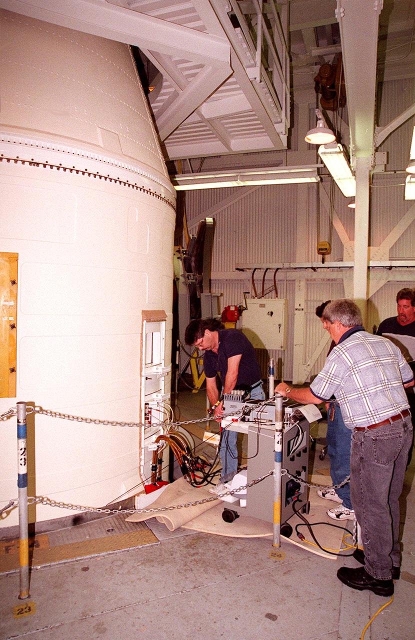 KENNEDY SPACE CENTER, FLA. -- Working near the top of a solid rocket booster, NASA and United Space Alliance SRB technicians hook up SRB cables to a Cirris Signature Touch 1 cable tester. From left are Steve Swichkow, with NASA, and Jim Silviano (back to camera) and Jeff Suter, with USA. The SRB is part of Space Shuttle Atlantis, rolled back from Launch Pad 39A in order to conduct tests on the cables. A prior extensive evaluation of NASA’s SRB cable inventory on the shelf revealed conductor damage in four (of about 200) cables. Shuttle managers decided to prove the integrity of the system tunnel cables already on Atlantis before launching. Workers are conducting inspections, making continuity checks and conducting X-ray analysis on the cables. The launch has been rescheduled no earlier than Feb. 6. <br