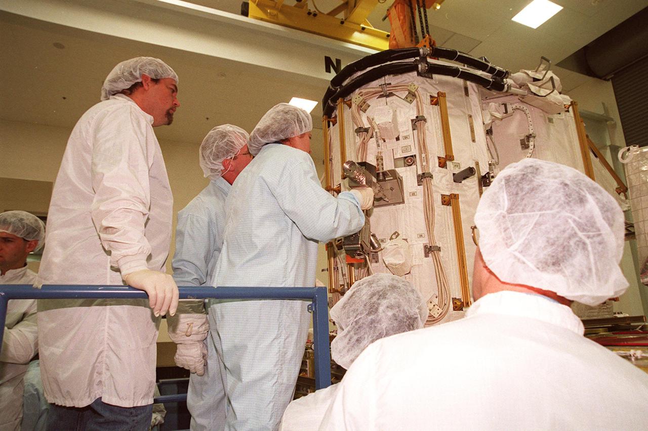 KENNEDY SPACE CENTER, FLA. -- At SPACEHAB, members of the STS-102 crew get acquainted with tools and equipment they will be using on their mission to the International Space Station. Susan Helms (center), who is part of the Expedition Two crew going to the International Space Station, practices with a tool on the Early Ammonia Servicer while Mission Specialist Andrew S.W. Thomas (next to her) looks on. The second spacewalk of the mission will require the crew to transfer the Early Ammonia Servicer to the P6 truss. STS-102 is the 8th construction flight to the International Space Station and will carry the Multi-Purpose Logistics Module Leonardo. On that flight, Leonardo will be filled with equipment and supplies to outfit the U.S. laboratory module Destiny. The mission will also be carrying the Expedition Two crew to the Space Station, replacing the Expedition One crew who will return on Shuttle Discovery. STS-102 is scheduled for launch March 8, 2001