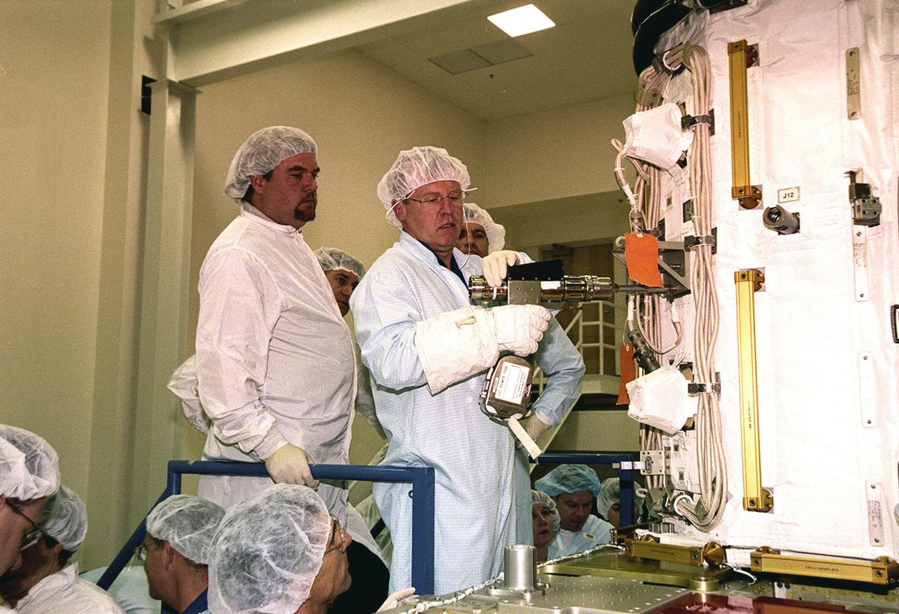 KENNEDY SPACE CENTER, FLA. -- At SPACEHAB, STS-102 Mission Specialist Andrew S.W. Thomas practices using a tool on the Early Ammonia Servicer under the watchful eyes of a technician. Thomas and other crew members are at SPACEHAB to get acquainted with tools and equipment they will be using on their mission to the International Space Station. The second spacewalk of the mission will require the crew to transfer the Early Ammonia Servicer to the P6 truss. STS-102 is the 8th construction flight to the Space Station and will carry the Multi-Purpose Logistics Module Leonardo. On that flight, Leonardo will be filled with equipment and supplies to outfit the U.S. laboratory module Destiny. The mission will also be carrying the Expedition Two crew to the Space Station, replacing the Expedition One crew who will return on Shuttle Discovery. STS-102 is scheduled for launch March 8, 2001