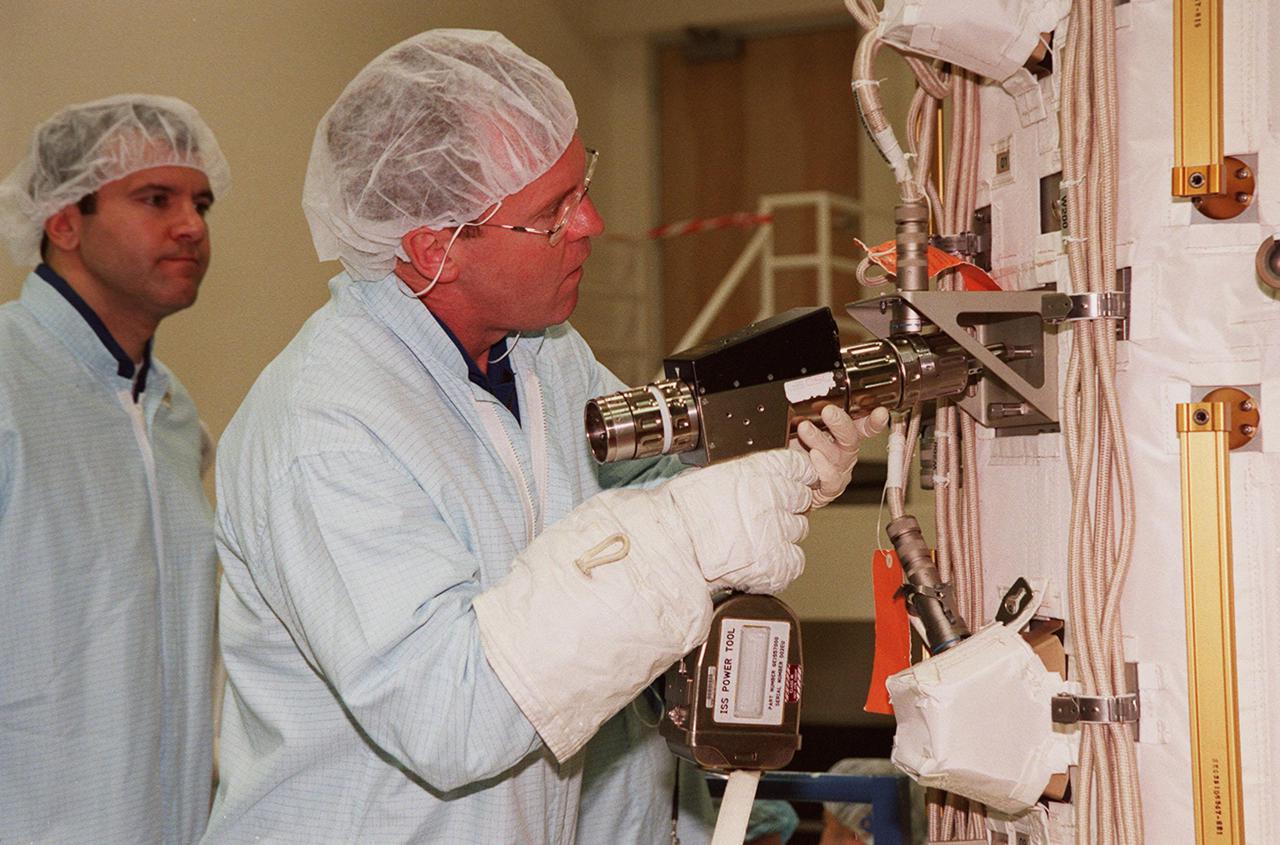 KENNEDY SPACE CENTER, FLA. -- At SPACEHAB, STS-102 Mission Specialist Andrew S.W. Thomas practices using a tool on the Early Ammonia Servicer while Mission Specialist Paul W. Richards (left) looks on. Thomas, Richards and other crew members are at SPACEHAB to get acquainted with tools and equipment they will be using on their mission to the International Space Station. The second spacewalk of the mission will require the crew to transfer the Early Ammonia Servicer to the P6 truss. STS-102 is the 8th construction flight to the International Space Station and will carry the Multi-Purpose Logistics Module Leonardo. On that flight, Leonardo will be filled with equipment and supplies to outfit the U.S. laboratory module Destiny. The mission will also be carrying the Expedition Two crew to the Space Station, replacing the Expedition One crew who will return on Shuttle Discovery. STS-102 is scheduled for launch March 8, 2001