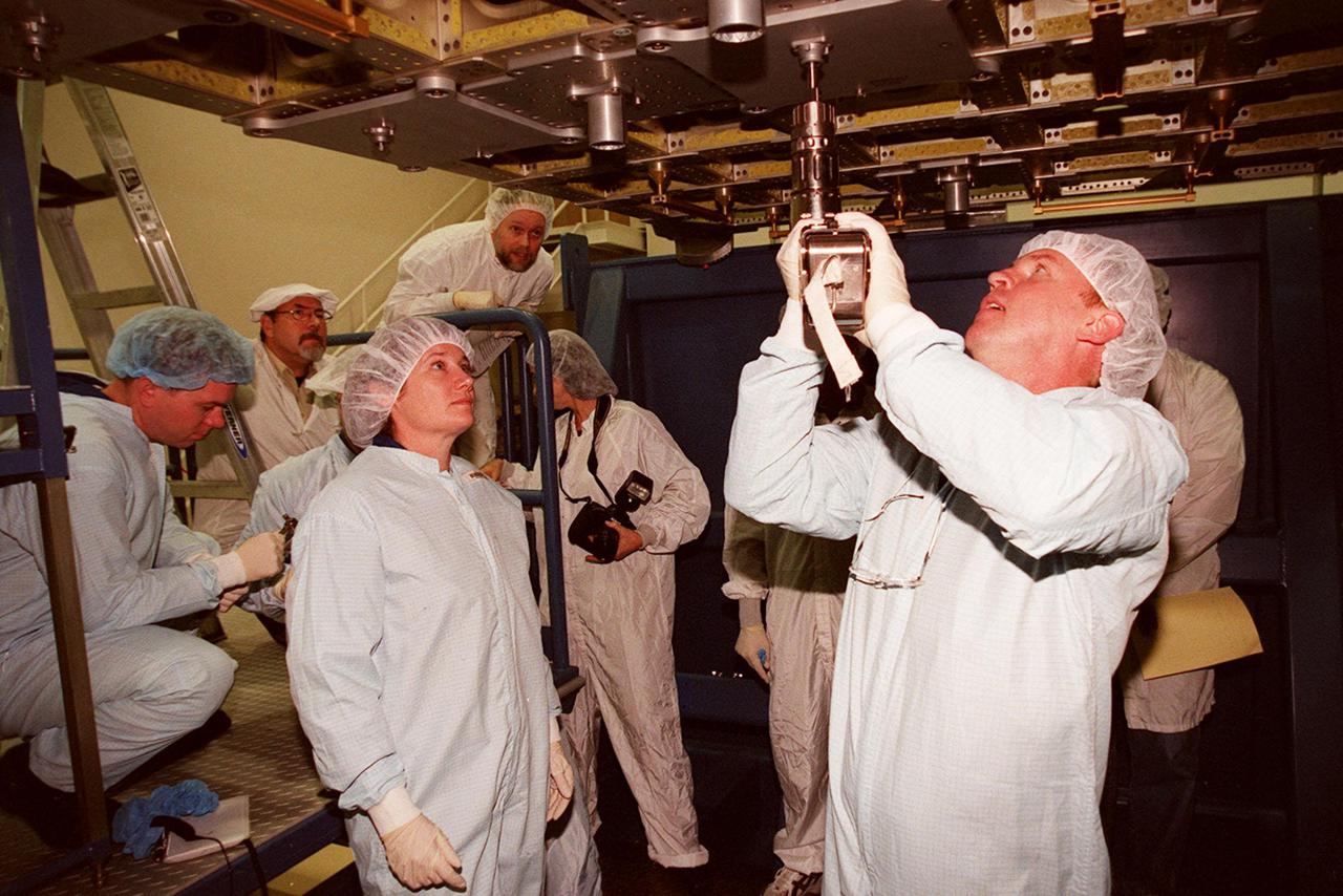 KENNEDY SPACE CENTER, FLA. -- At SPACEHAB, STS-102 Mission Specialist Andrew S.W. Thomas practices using a tool on the Integrated Cargo Carrier. Watching him, at left, is Susan Helms, part of the Expedition Two crew heading for the International Space Station on the flight. Behind Helms (at left) is Pilot James M. Kelly. They and other crew members are at SPACEHAB to get acquainted with tools and equipment they will be using on their mission. STS-102 is the 8th construction flight to the International Space Station and will carry the Multi-Purpose Logistics Module Leonardo. On that flight, Leonardo will be filled with equipment and supplies to outfit the U.S. laboratory module Destiny. The mission will also be carrying the Expedition Two crew to the Space Station, replacing the Expedition One crew who will return on Shuttle Discovery. STS-102 is scheduled for launch March 8, 2001