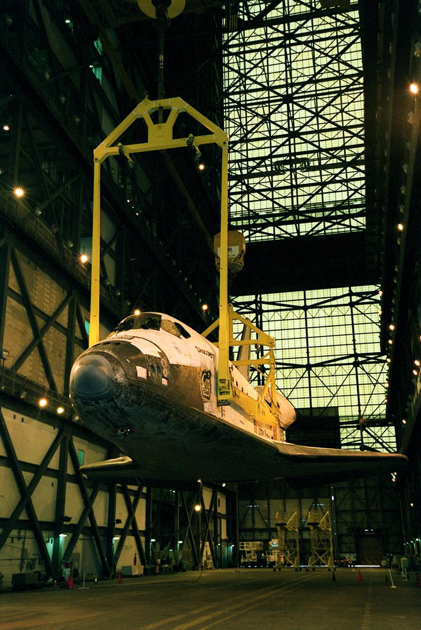The orbiter Discovery is lifted by cranes in the transfer aisle of the Vehicle Assembly Building. It will next be lifted into a vertical position and into high bay 1 for mating with its solid rocket boosters and external tank. Discovery will be launched March 8 on mission STS-102, the eighth construction flight to the International Space Station. The Shuttle will carry the Multi-Purpose Logistics Module Leonardo, the first of three pressurized modules provided by the Italian Space Agency to carry supplies and equipment to the Space Station and back to Earth