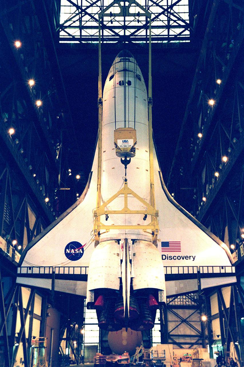 The orbiter Discovery finally hangs vertically, suspended from overhead cranes in the transfer aisle of the Vehicle Assembly Building. It will next be lifted into high bay 1 for mating with its solid rocket boosters and external tank. Discovery will be launched March 8 on mission STS-102, the eighth construction flight to the International Space Station. The Shuttle will carry the Multi-Purpose Logistics Module Leonardo, the first of three pressurized modules provided by the Italian Space Agency to carry supplies and equipment to the Space Station and back to Earth