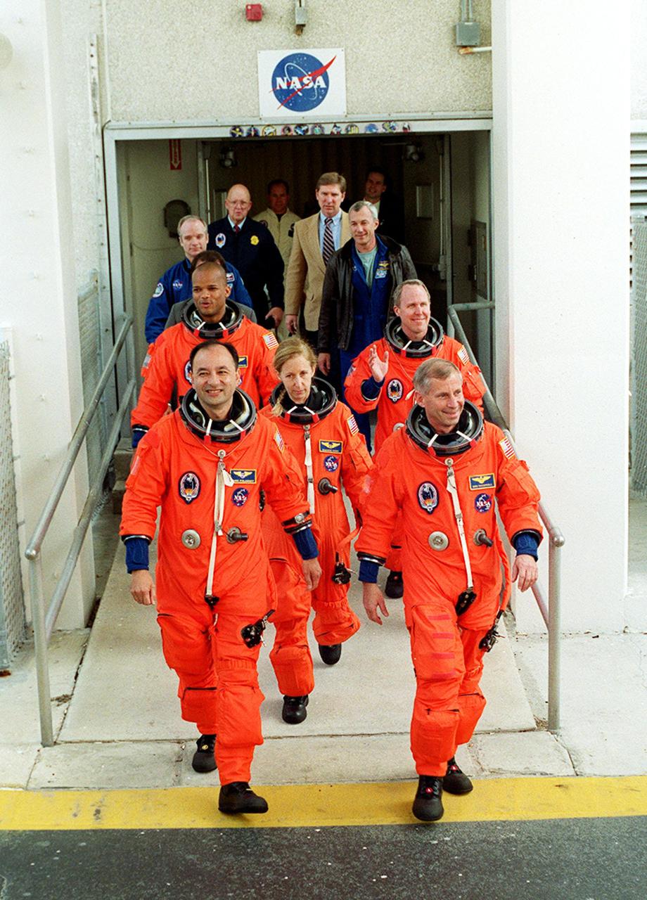 The STS-98 crew eagerly exits the Operations and Checkout Building to head for Space Shuttle Atlantis on Launch Pad 39A. Leading the crew are Pilot Mark Polansky (left) and Commander Ken Cockrell (right). In the center is Mission Specialist Marsha Ivins. Behind her are Mission Specialists Robert Curbeam (left) and Thomas Jones (right). They will be flying the seventh construction flight to the International Space Station. Atlantis is carrying the U.S. Laboratory Destiny, a key module in the growth of the Space Station. Destiny will be attached to the Unity node on the Space Station using the Shuttle’s robotic arm. Three spacewalks are required to complete the planned construction work during the 11-day mission. Launch is targeted for 6:11 p.m. EST and the planned landing at KSC Feb. 18 about 1:39 p.m. This mission marks the seventh Shuttle flight to the Space Station, the 23rd flight of Atlantis and the 102nd flight overall in NASA’s Space Shuttle program