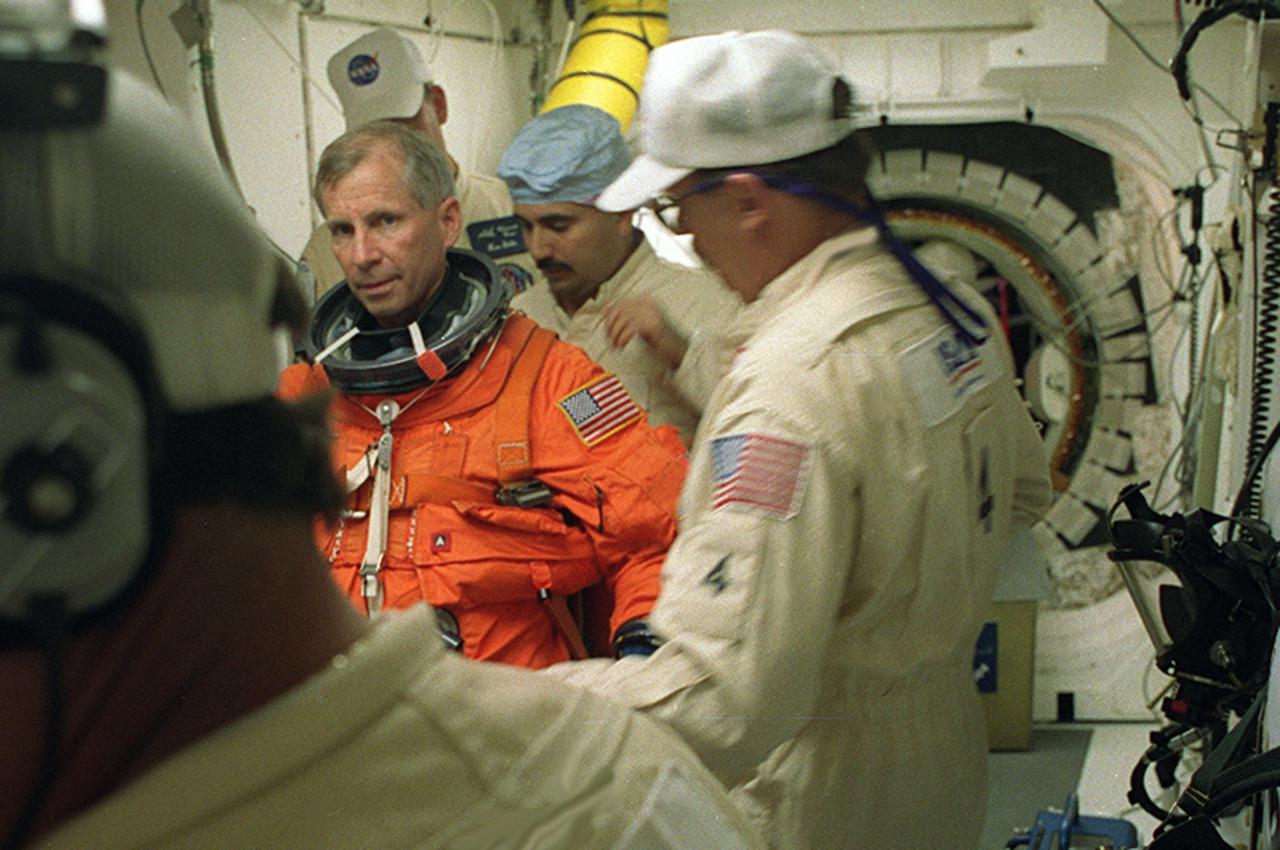 The closeout crew in the White Room help STS-98 Commander Ken Cockrell with final suitup before entering Space Shuttle Atlantis for launch. The White Room is an environmentally controlled room at the end of the Orbiter Access Arm. Atlantis is carrying the U.S. Laboratory Destiny, a key module in the growth of the Space Station. Destiny will be attached to the Unity node on the Space Station using the Shuttle’s robotic arm. Three spacewalks are required to complete the planned construction work during the 11-day mission. This mission marks the seventh Shuttle flight to the Space Station, the 23rd flight of Atlantis and the 102nd flight overall in NASA’s Space Shuttle program. The planned landing is at KSC Feb. 18 about 1 p.m
