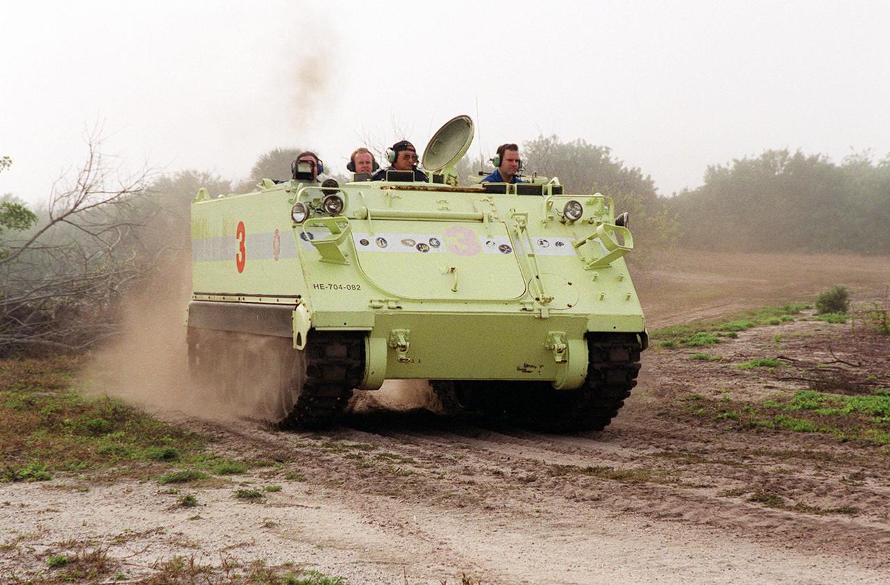 STS-102 Mission Specialist Paul Richards kicks up dust as he makes a turn while driving the M-113 armored carrier, part of emergency egress training at Launch Pad 39B. Seated alongside (at left) is Capt. George Hoggard, a training officer with SGS Fire Services. In the event of an emergency at the pad prior to launch, the M-113 could be used to transport the crew to a nearby bunker or farther. The STS-102 crew is at KSC to take part in Terminal Countdown Demonstration Test activities, which also include a simulated launch countdown. STS-102 is the eighth construction flight to the International Space Station, carrying as payload the Multi-Purpose Logistics Module Leonardo. Launch on mission STS-102 is scheduled for March 8