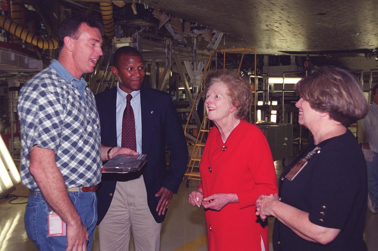 In the Orbiter Processing Facility bay 2, standing underneath the orbiter Endeavour are United Space Alliance technician Mike Parrish, NASA Test Director Kelvin Manning, Lady Margaret Thatcher, former Prime Minister of Britain, and JoAnn H. Morgan, director, External Relations and Business Development at KSC.  Thatcher is on a tour of KSC.  Parrish will be her guide inside the orbiter Endeavour, which is next flying on mission STS-100, the ninth construction flight to the International Space Station