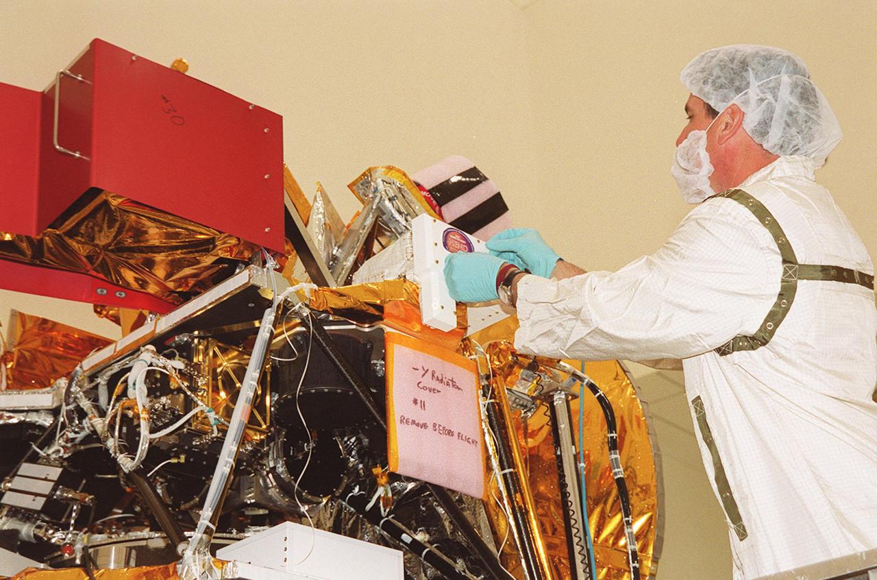 In the Spacecraft Assembly and Encapsulation Facility 2 (SAEF-2), a worker removes the High Energy Neutron Detector (HEND), part of the Gamma Ray Spectrometer (GRS), from the 2001 Mars Odyssey Orbiter. The HEND was built by Russia’s Space Research Institute (IKI). The GRS will achieve global mapping of the elemental composition of the surface and determine the abundance of hydrogen in the shallow subsurface. The orbiter will carry two other science instruments: THEMIS and the Mars Radiation Environment Experiment (MARIE). THEMIS will map the mineralogy and morphology of the Martian surface using a high-resolution camera and a thermal infrared imaging spectrometer. The MARIE will characterize aspects of the near-space radiation environment with regards to the radiation-related risk to human explorers. The Mars Odyssey Orbiter is scheduled for launch April 7, 2001, aboard a Delta 7925 rocket from Launch Pad 17-A, Cape Canaveral Air Force Station
