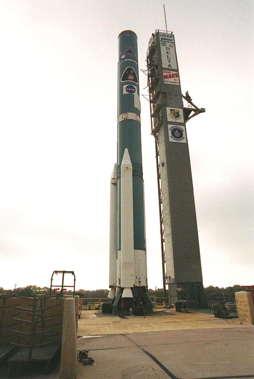 A Delta 7925 rocket on Launch Pad 17-A, Cape Canaveral Air Force Station, is being erected for launch April 7, 2001. The rocket will carry the 2001 Mars Odyssey Orbiter, containing three science instruments: THEMIS, the Gamma Ray Spectrometer (GRS), and the Mars Radiation Environment Experiment (MARIE). THEMIS will map the mineralogy and morphology of the Martian surface using a high-resolution camera and a thermal infrared imaging spectrometer. The GRS will achieve global mapping of the elemental composition of the surface and determine the abundance of hydrogen in the shallow subsurface. The MARIE will characterize aspects of the near-space radiation environment with regards to the radiation-related risk to human explorers