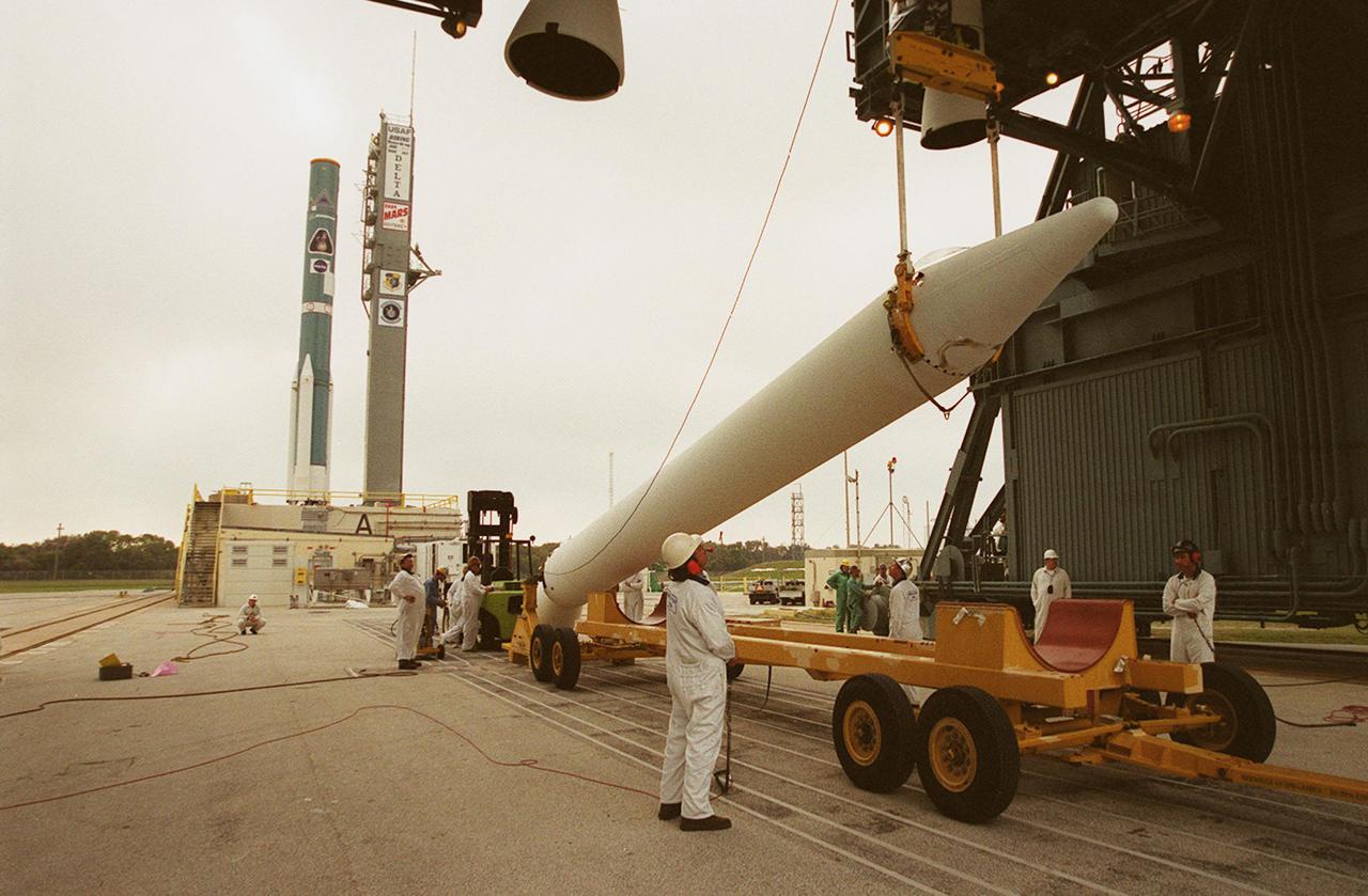 A crane lifts a solid rocket booster on Launch Pad 17-A, Cape Canaveral Air Force Station, where it will be mated with a Delta 7925 rocket for launch April 7, 2001. The rocket will carry the 2001 Mars Odyssey Orbiter, containing three science instruments: THEMIS, the Gamma Ray Spectrometer (GRS), and the Mars Radiation Environment Experiment (MARIE). THEMIS will map the mineralogy and morphology of the Martian surface using a high-resolution camera and a thermal infrared imaging spectrometer. The GRS will achieve global mapping of the elemental composition of the surface and determine the abundance of hydrogen in the shallow subsurface. The MARIE will characterize aspects of the near-space radiation environment with regards to the radiation-related risk to human explorers