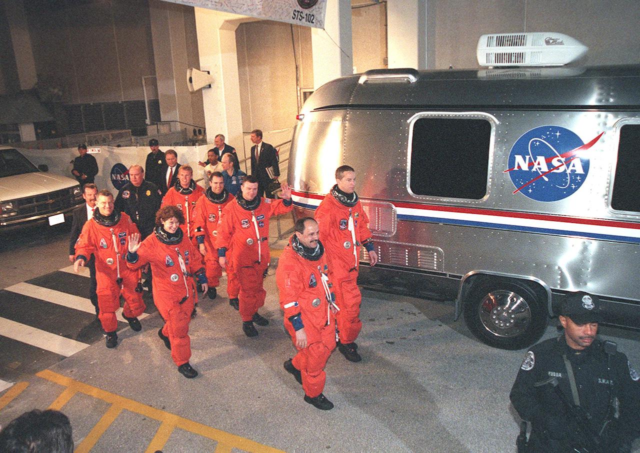 The STS-102 crew heads for the Astrovan after leaving the Operations and Checkout Building behind them. In front, left to right, are Mission Specialists James Voss, Susan Helms and Yury Usachev. In back, left to right, are Mission Specialists Andrew Thomas and Paul Richards, Pilot James Kelly and Commander James Wetherbee. STS-102 is the eighth construction flight to the Space Station, carrying the Multi-Purpose Logistics Module Leonardo. The primary delivery system used to resupply and return Station cargo requiring a pressurized environment, Leonardo will deliver up to 10 tons of laboratory racks filled with equipment, experiments and supplies for outfitting the newly installed U.S. Laboratory Destiny. In addition, Voss, Helms and Usachev, known as Expedition Two, are flying to the Station to replace Expedition One, who will return to Earth on Discovery. Discovery is set to launch March 8 at 6:42 a.m. EST. The 12-day mission is expected to end with a landing at KSC on March 20
