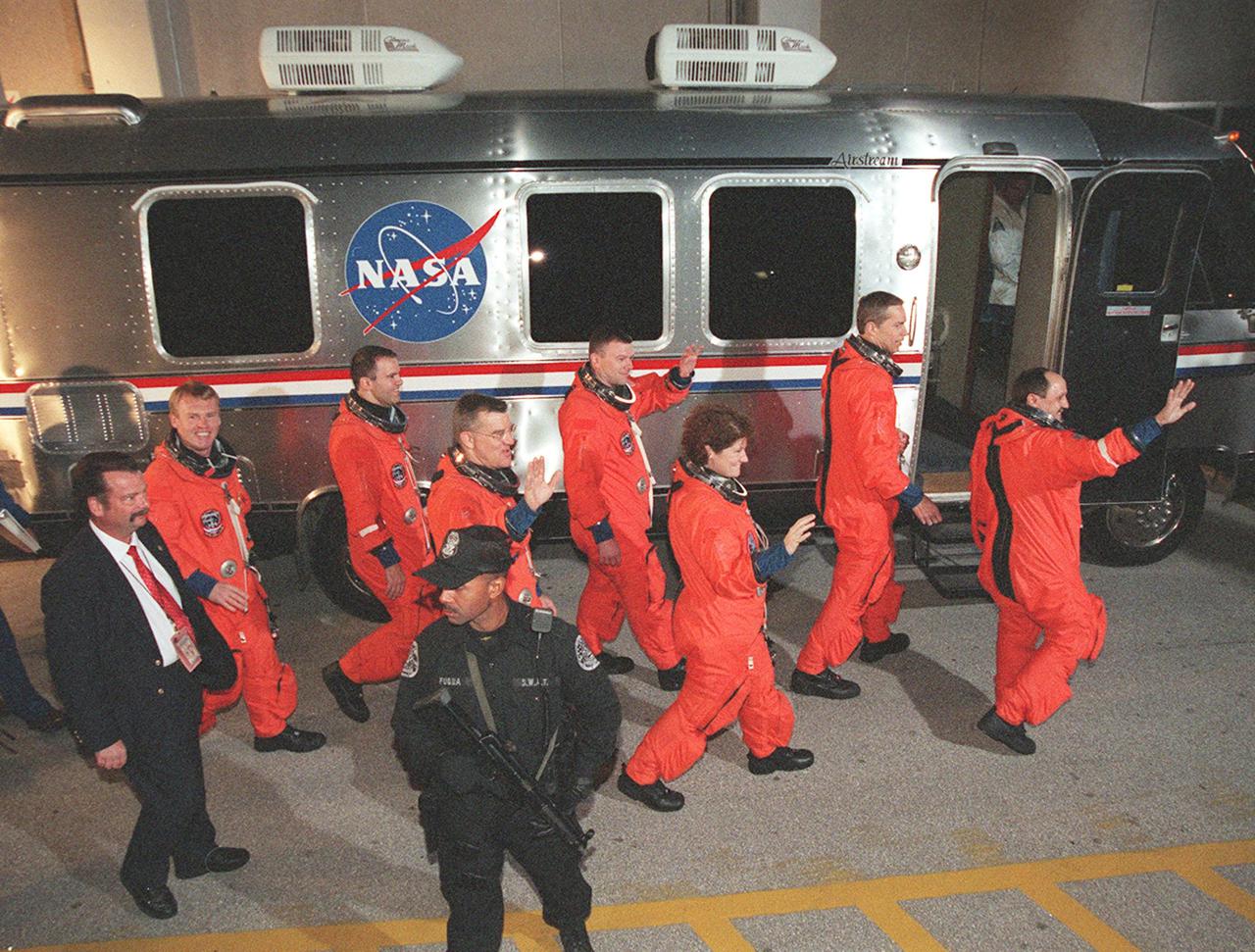 The STS-102 crew wave to onlookers as they head for the Astrovan after leaving the Operations and Checkout Building. Left to right are Mission Specialists Andrew Thomas, Paul Richards and James Voss; Pilot James Kelly; Mission Specialist Susan Helms; Commander James Wetherbee; and Mission Specialist Yury Usachev. STS-102 is the eighth construction flight to the Space Station, carrying the Multi-Purpose Logistics Module Leonardo. The primary delivery system used to resupply and return Station cargo requiring a pressurized environment, Leonardo will deliver up to 10 tons of laboratory racks filled with equipment, experiments and supplies for outfitting the newly installed U.S. Laboratory Destiny. In addition, Voss, Helms and Usachev, known as Expedition Two, are flying to the Station to replace Expedition One, who will return to Earth on Discovery. Discovery is set to launch March 8 at 6:42 a.m. EST. The 12-day mission is expected to end with a landing at KSC on March 20