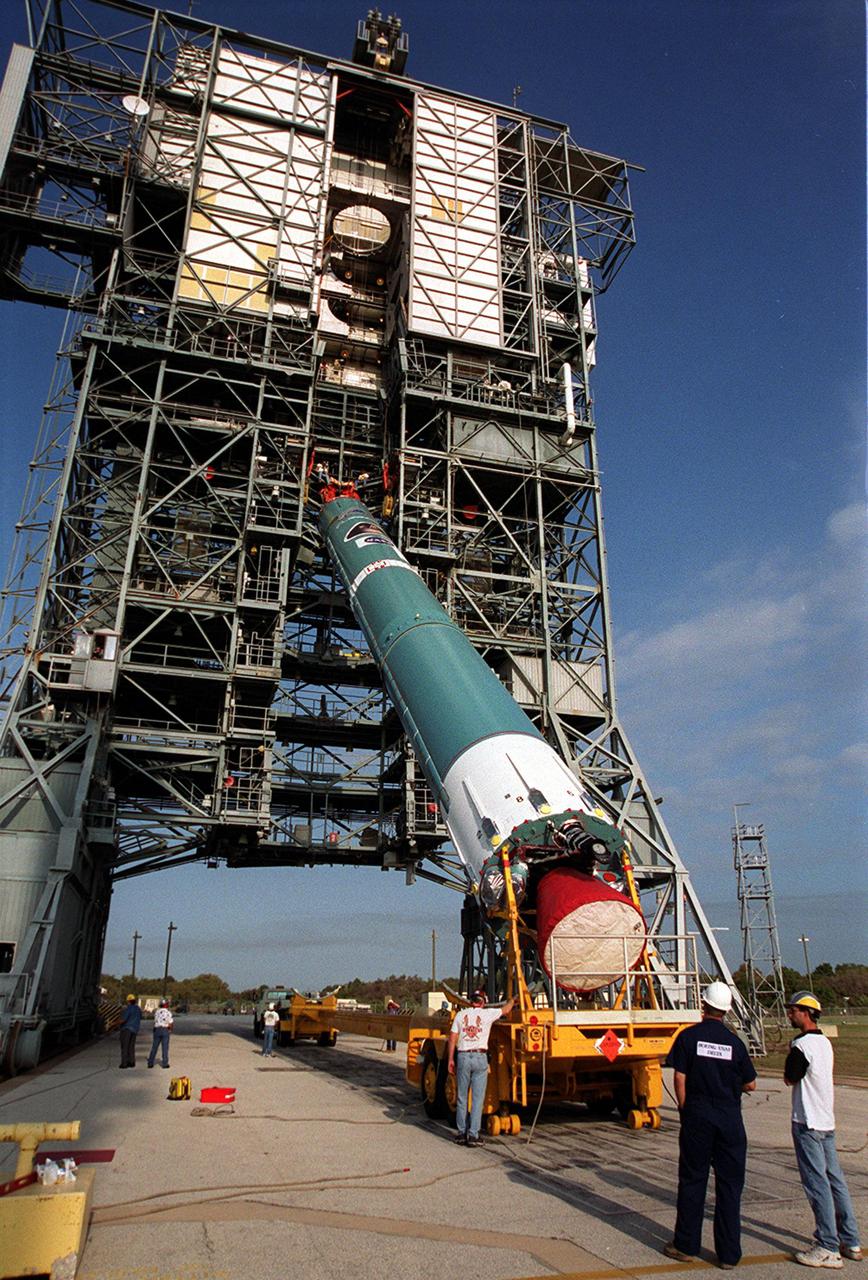 Cranes on the gantry on Launch Pad 17-A, Cape Canaveral Air Force Station, lift the first stage of a Boeing Delta rocket to a vertical position. The rocket will carry the 2001 Mars Odyssey Orbiter, scheduled for launch April 7, 2001. Mars Odyssey contains three science instruments: THEMIS, the Gamma Ray Spectrometer (GRS), and the Mars Radiation Environment Experiment (MARIE). THEMIS will map the mineralogy and morphology of the Martian surface using a high-resolution camera and a thermal infrared imaging spectrometer. The GRS will achieve global mapping of the elemental composition of the surface and determine the abundance of hydrogen in the shallow subsurface. The MARIE will characterize aspects of the near-space radiation environment with regards to the radiation-related risk to human explorers