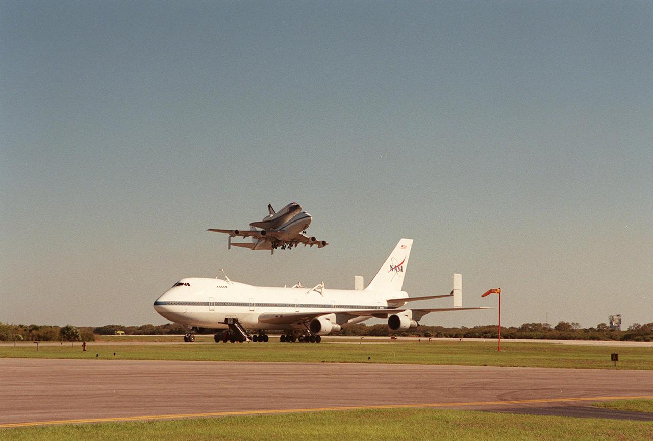 The Shuttle Carrier Aircraft with orbiter Columbia on top takes off from the Cape Canaveral Air Force Station Skid Strip. In the foreground is another SCA, which brought Atlantis back to KSC from California. The ferry flight began in California March 1. Unfavorable weather conditions kept it on the ground at Dyess AFB, Texas, until it could return to Florida. Columbia is returning from a 17-month-long modification and refurbishment process as part of a routine maintenance plan. The orbiter will next fly on mission STS-107, scheduled Oct. 25
