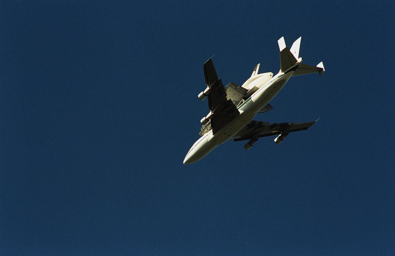 The Shuttle Carrier Aircraft with orbiter Columbia on top is viewed from underneath as it soars through the sky over the Space Coast of Florida as it returns to KSC from Cape Canaveral Air Force Station. The ferry flight began in California March 1. Unfavorable weather conditions kept it on the ground at Dyess AFB, Texas, until it could return to Florida. It landed temporarily at the CCAFS Skid Strip until Atlantis, which had already landed at the SLF, could be transferred. Columbia is returning from a 17-month-long modification and refurbishment process as part of a routine maintenance plan. The orbiter will next fly on mission STS-107, scheduled Oct. 25