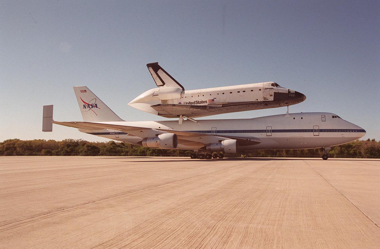 This is a closer view of the Shuttle Carrier Aircraft with orbiter Columbia riding piggyback as the SCA taxis toward the mate_demate device at the KSC Shuttle Landing Facility. At the MDD, Columbia will be lifted off the SCA and towed to the Orbiter Processing Facility bay 1. Columbia’s ferry flight began in California March 1. Unfavorable weather conditions kept it on the ground at Dyess AFB, Texas, until it could return to Florida. It landed temporarily at the CCAFS Skid Strip until Atlantis, which had already landed at the SLF, could be transferred. Columbia is returning from a 17-month-long modification and refurbishment process as part of a routine maintenance plan. The orbiter will next fly on mission STS-107, scheduled Oct. 25