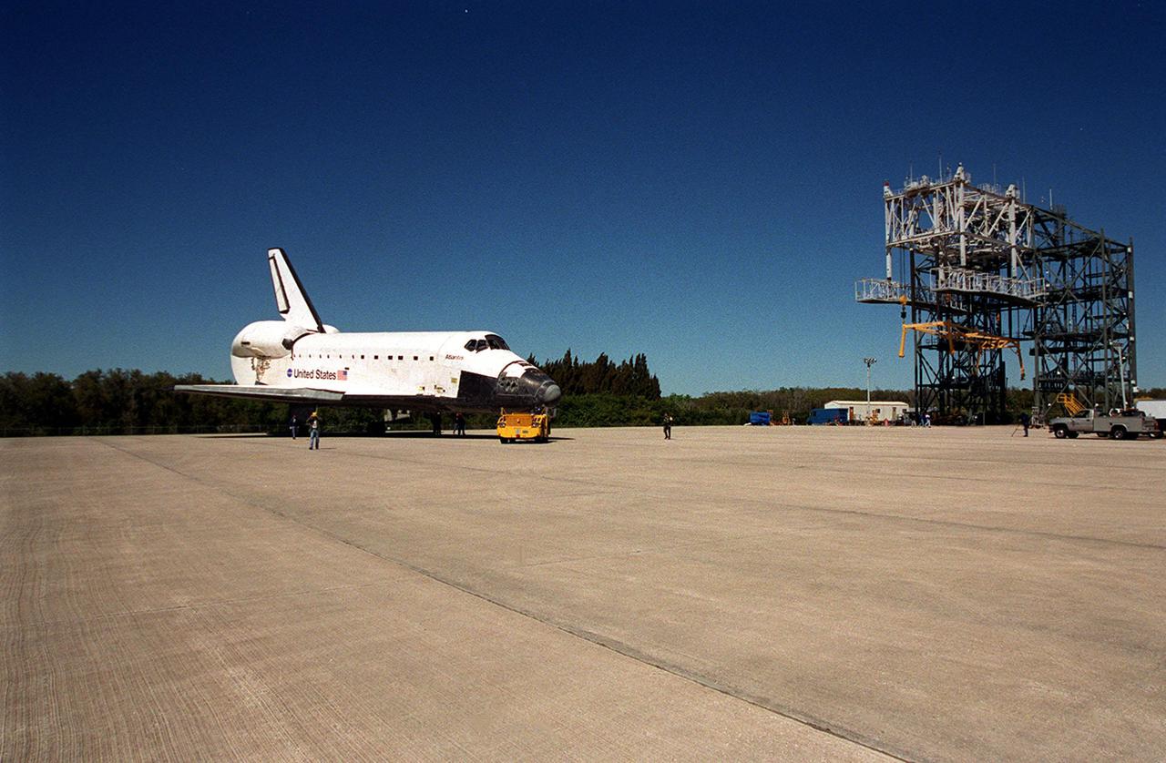 Atlantis turns away from the mate_demate device at KSC’s Shuttle Landing Facility for towing to the Orbiter Processing Facility. Atlantis returned from California atop a Shuttle Carrier Aircraft after its Feb. 19 landing at Edwards Air Force Base, concluding mission STS-98. The ferry flight began March 1; unfavorable weather conditions kept it on the ground at Altus AFB, Okla., until it could return to Florida. In the Orbiter Processing Facility, Atlantis will be prepared for mission STS-104, the 10th construction flight to the International Space Station, scheduled to launch June 8