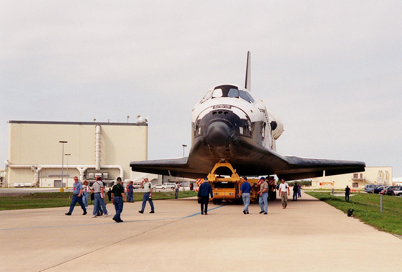 KENNEDY SPACE CENTER, FLA. -- Accompanied by workers, Endeavour rolls to the Vehicle Assembly Building after leaving Orbiter Processing Facility bay 2 (background). In the VAB, Endeavour will be stacked with its solid rocket boosters and external tank atop the Mobile Launcher Platform in high bay 3. Endeavour is scheduled to launch April 19 on mission STS-100, the ninth flight to the International Space Station