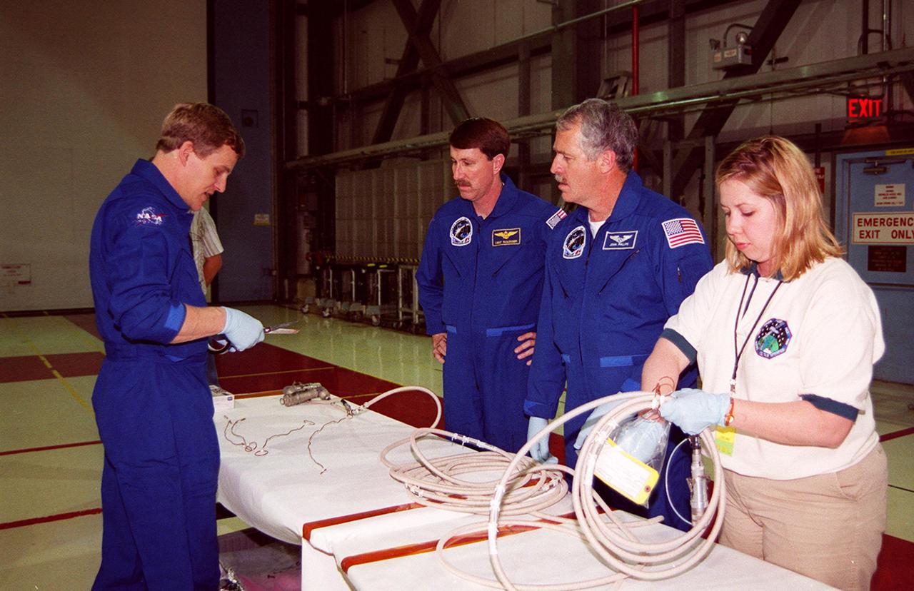 STS-100 Mission Specialists Scott Parazynski (left), Chris Hadfield (center), who is with the Canadian Space Agency, and John L. Phillips look over equipment that will be used during their mission. They are taking part in a Crew Equipment Interface Test (CEIT) at KSC, along with other crew members Commander Kent V. Rominger, Pilot Jeffrey S. Ashby and Mission Specialists Umberto Guidoni, who is with the European Space Agency, and Yuri Lonchakov, who is with the Russian Aviation and Space Agency. The orbiter is also carrying the Multi-Purpose Logistics Module Raffaello to the International Space Station. Raffaello carries six system racks and two storage racks for the U.S. Lab. Launch of mission STS-100 is scheduled for April 19 at 2:41 p.m. EDT from Launch Pad 39A