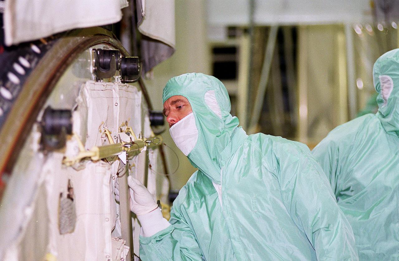 Dressed in protective clothing, STS-100 Mission Specialist Chris Hadfield looks at equipment in the payload bay of orbiter Endeavour during a Crew Equipment Interface Test (CEIT). Other crew members at KSC for the CEIT are Commander Kent V. Rominger, Pilot Jeffrey S. Ashby and Mission Specialists Scott Parazynski, John L. Phillips, Umberto Guidoni, who is with the European Space Agency, and Yuri Lonchakov, who is with the Russian Aviation and Space Agency. Hadfield is with the Canadian Space Agency. Endeavour is also carrying the Multi-Purpose Logistics Module Raffaello to the International Space Station. Raffaello carries six system racks and two storage racks for the U.S. Lab. Launch of mission STS-100 is scheduled for April 19 at 2:41 p.m. EDT from Launch Pad 39A
