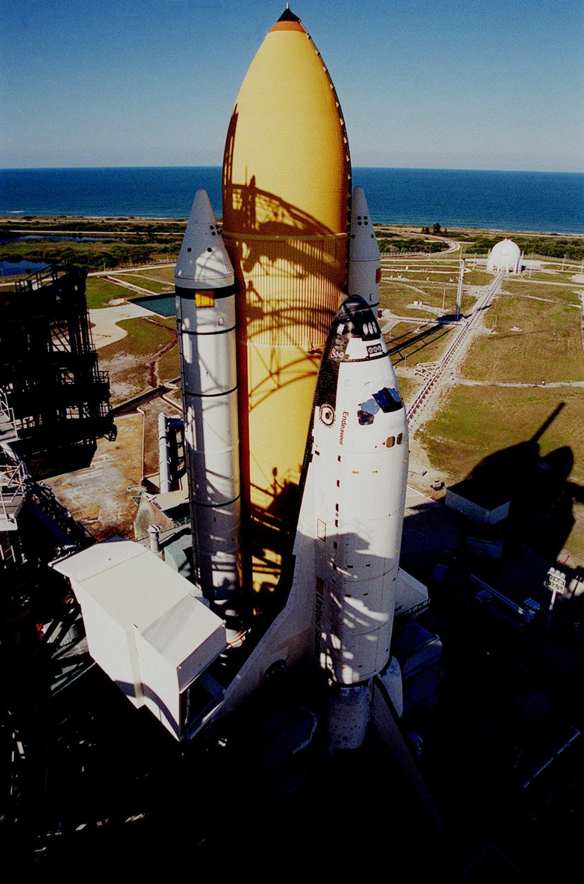 KENNEDY SPACE CENTER, FLA. -- Afternoon shadows cast a grid over the Space Shuttle Endeavour’s white solid rocket boosters and orange external tank after arriving on Launch Pad 39A. In the background is seen the deep blue of the Atlantic Ocean. Endeavour is expected to lift off on mission STS-100 on April 19, carrying the Multi-Purpose Logistics Module Raffaello and the Canadian robotic arm, SSRMS, to the International Space Station
