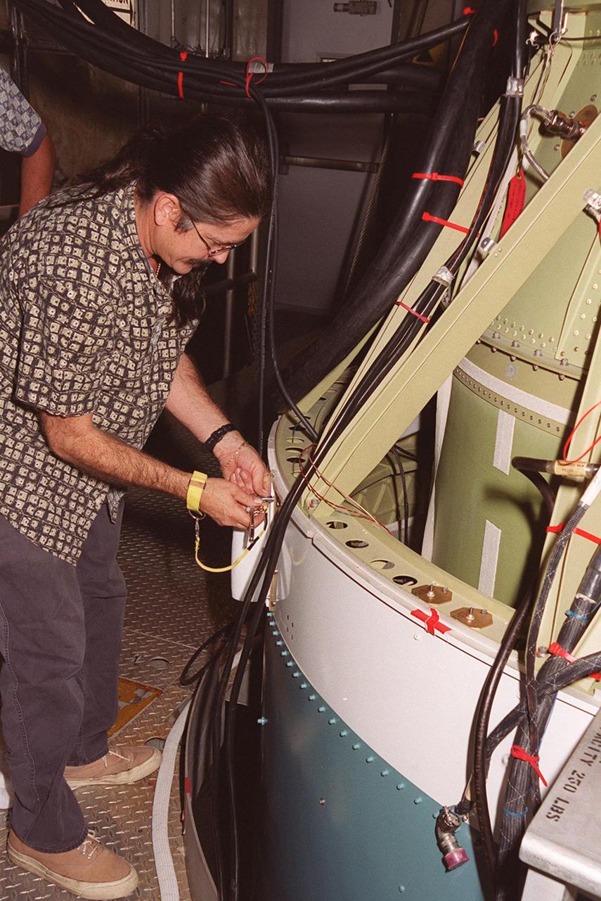 At Launch Pad 17-A, Cape Canaveral Air Force Station, a worker prepares the site before attaching a camera to the second stage of the Delta II rocket for the Mars Odyssey launch. The orbiter carries three science instruments THEMIS, the Gamma Ray Spectrometer (GRS), and the Mars Radiation Environment Experiment (MARIE) that will map the mineralogy and morphology of the Martian surface. The Mars Odyssey Orbiter is scheduled for launch on April 7, 2001