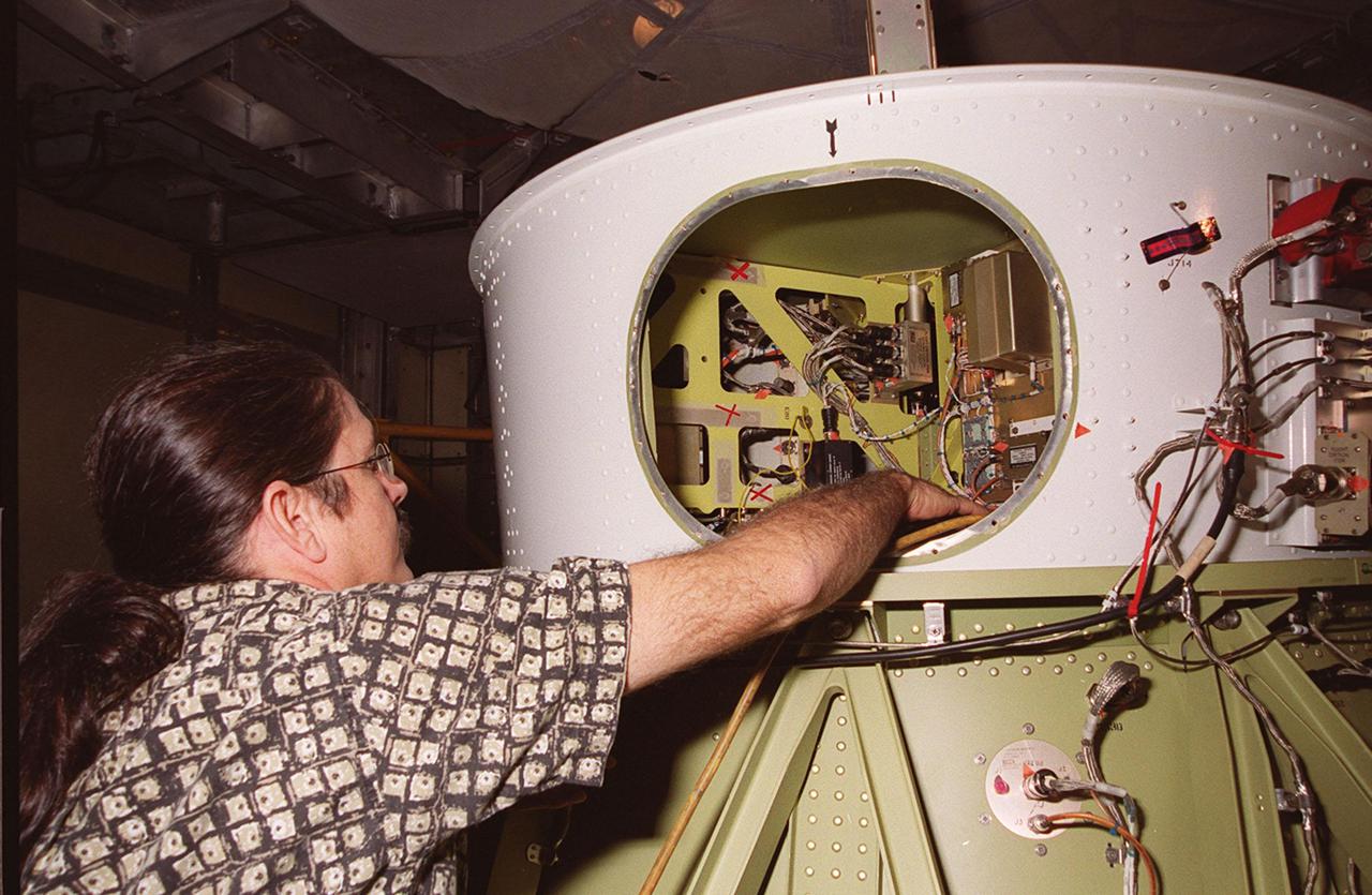 At Launch Pad 17-A, Cape Canaveral Air Force Station, a worker checks the wiring for a camera attached to the second stage of the Delta II rocket for the Mars Odyssey launch. The orbiter carries three science instruments THEMIS, the Gamma Ray Spectrometer (GRS), and the Mars Radiation Environment Experiment (MARIE) that will map the mineralogy and morphology of the Martian surface. The Mars Odyssey Orbiter is scheduled for launch on April 7, 2001