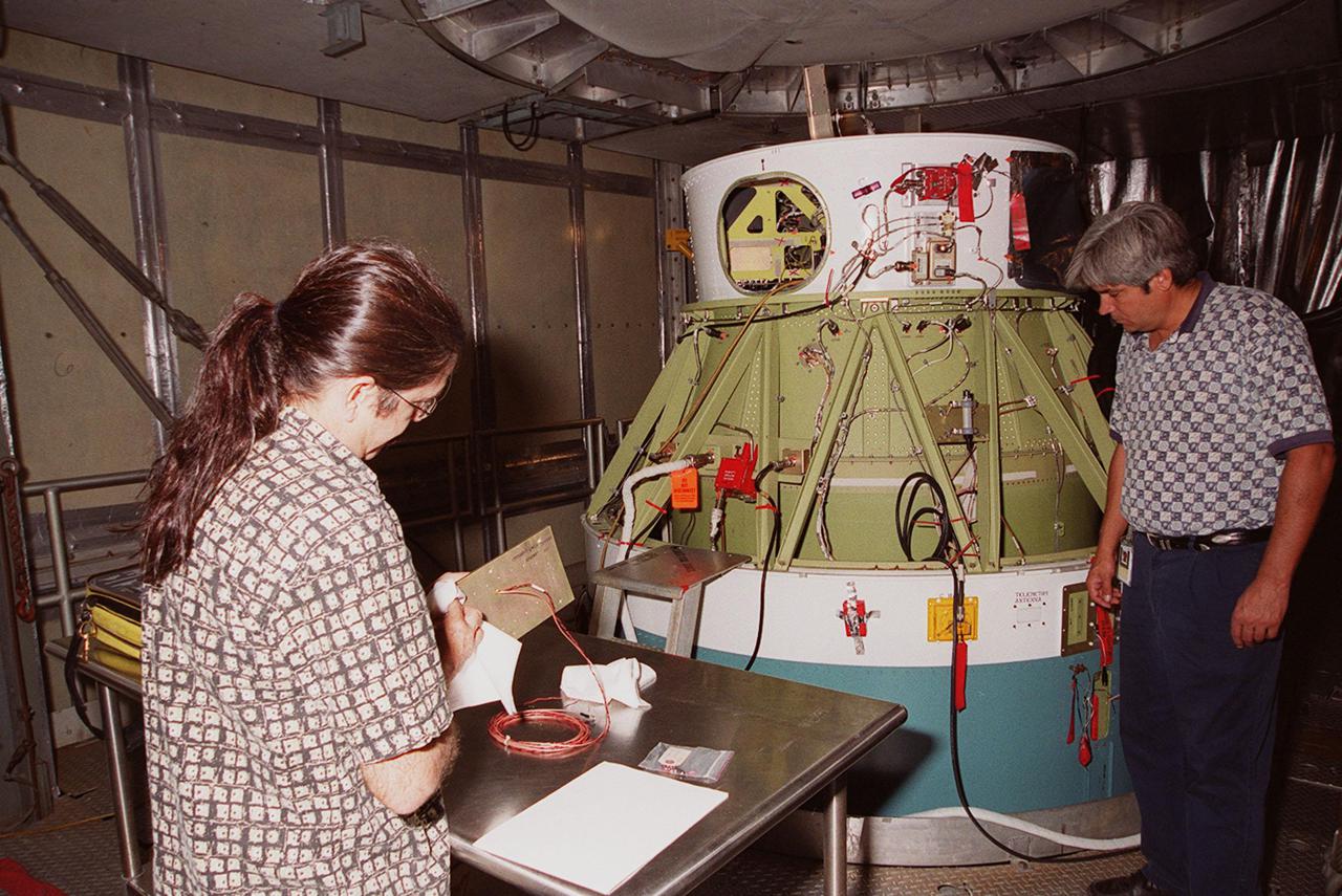 A worker (right) at Launch Pad 17-A, Cape Canaveral Air Force Station, looks at the camera recently attached to the second stage of the Delta II rocket for the Mars Odyssey launch. The orbiter carries three science instruments THEMIS, the Gamma Ray Spectrometer (GRS), and the Mars Radiation Environment Experiment (MARIE) that will map the mineralogy and morphology of the Martian surface. The Mars Odyssey Orbiter is scheduled for launch on April 7, 2001