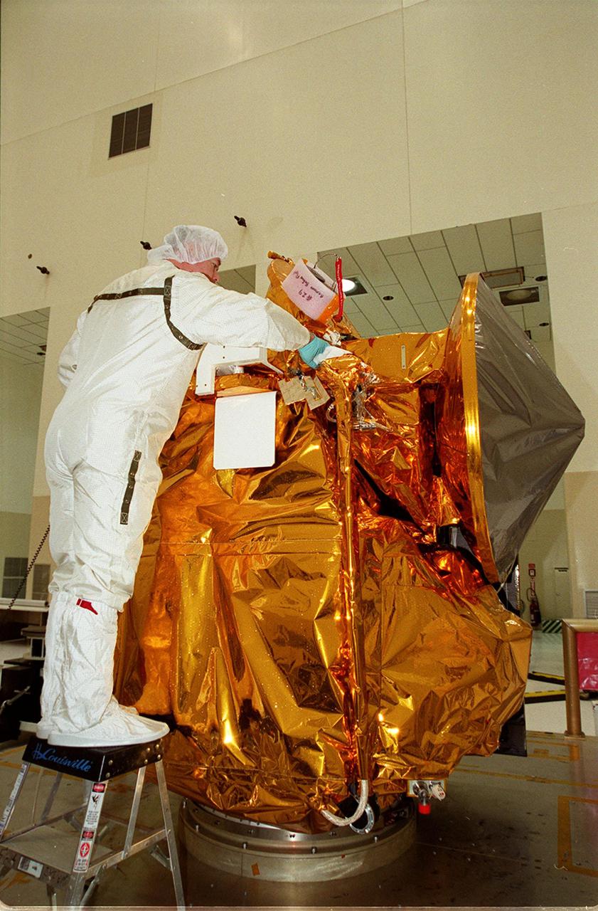 A worker in the Space Assembly and Encapsulation Facility 2 checks out the Mars Odyssey Orbiter before its move to the third stage of a Delta rocket. The Mars Odyssey is scheduled for launch on April 7, 2001, aboard a Delta II rocket from Launch Pad 17-A, Cape Canaveral Air Force Station