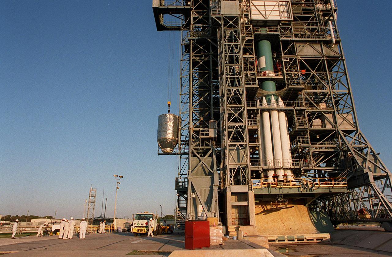 With the Delta II rocket’s first and second stages standing by (right), the Mars Odyssey orbiter is lifted up the gantry on Launch Pad 17-A, Cape Canaveral Air Force Station, for mating with the Delta II. The spacecraft will map the Martian surface in search of geological features that could indicate the presence of water, now or in the past, and may contribute significantly toward understanding what will be necessary for a more sophisticated exploration of Mars. Launch is scheduled for 11:02 a.m. EDT April 7