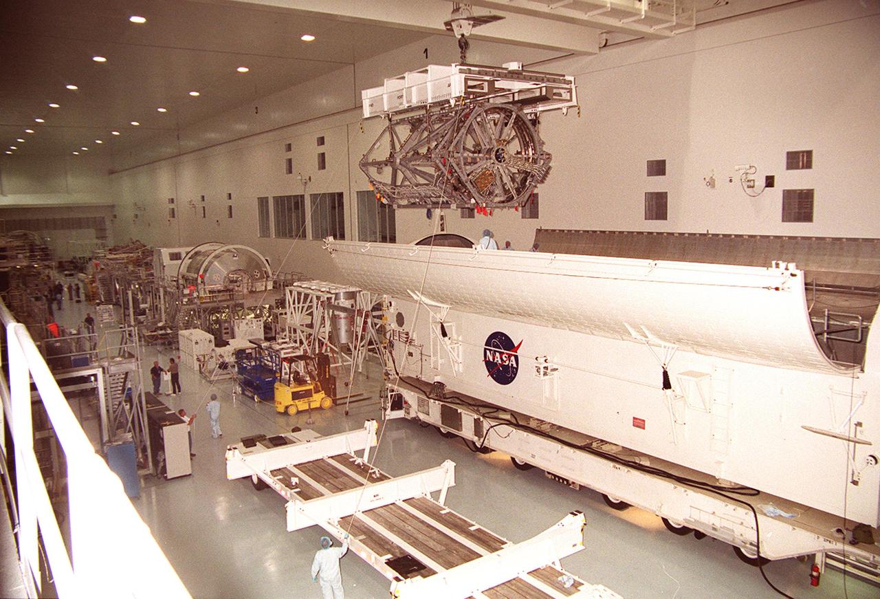 KENNEDY SPACE CENTER, FLA. -- In the Space Station Processing Facility, an overhead crane lifts the P3 Integrated Truss Structure clear of the payload canister that transferred it from the Operations and Checkout Building. The port-side P3 truss is scheduled to be added to the International Space Station on mission STS-115 in 2002 aboard Space Shuttle Atlantis. . The P3 will be attached to the first port truss segment, P1, being installed in an earlier mission