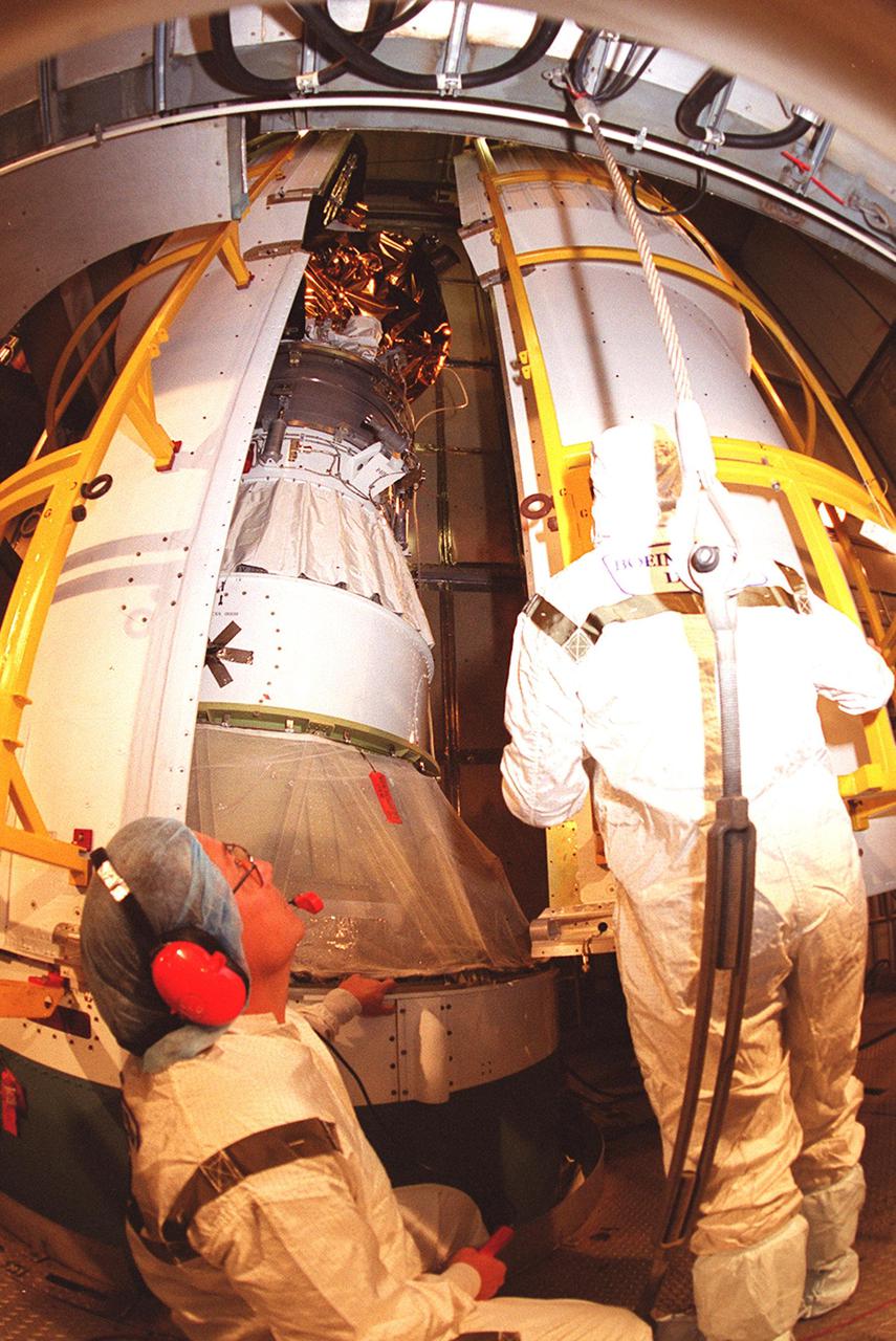 Workers at Launch Complex 17-A, Cape Canaveral Air Force Station, watch as the two parts of the Delta rocket fairing enclose the Mars Odyssey spacecraft. NASA’s latest explorer carries three scientific instruments to map the chemical and mineralogical makeup of Mars: a thermal-emission imaging system, a gamma ray spectrometer and a Martian radiation environment experiment. The imaging system will map the planet with high-resolution thermal images and give scientists an increased level of detail to help them understand how the mineralogy of the planet relates to the land forms. In addition, Odyssey will serve as a communications relay for U.S. and international landers arriving at Mars in 2003_2004. The Mars Odyssey is scheduled for launch aboard a Delta II rocket April 7, 2001, at 11:02 a.m. EST