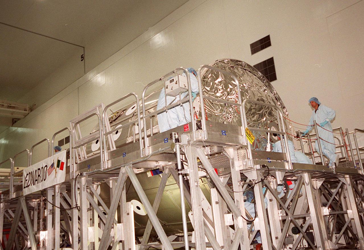 KENNEDY SPACE CENTER, FLA. -- The Multi-Purpose Logistics Module Leonardo sits on a workstand in the Space Station Processing Facility. Workers will be removing the protective cover over the end so they can open the hatch and access the inside. The MPLM has just returned from its maiden voyage to the International Space Station aboard Discovery on mission STS-102. Leonardo is one of three MPLMs built by the Italian Space Agency to serve as “cargo vans” to the Station, carrying supplies and equipment. In the SSPF, Leonardo will be prepared for a future mission