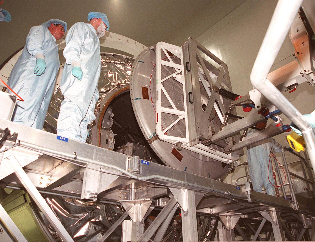 KENNEDY SPACE CENTER, FLA. -- In the Space Station Processing Facility, workers look on as the hatch on Multi-Purpose Logistics Module Leonardo opens. The MPLM has just returned from its maiden voyage to the International Space Station aboard Discovery on mission STS-102. Leonardo is one of three MPLMs built by the Italian Space Agency to serve as “cargo vans” to the Station, carrying supplies and equipment. In the SSPF, Leonardo will be prepared for a future mission