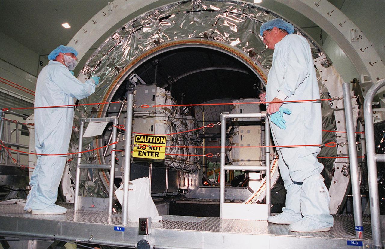 KENNEDY SPACE CENTER, FLA. -- Workers in the Space Station Processing Facility look at the cargo inside the Multi-Purpose Logistics Module Leonardo revealed when the hatch was removed. The MPLM has just returned from its maiden voyage to the International Space Station aboard Discovery on mission STS-102. Leonardo is one of three MPLMs built by the Italian Space Agency to serve as “cargo vans” to the Station, carrying supplies and equipment. In the SSPF, Leonardo will be prepared for a future mission