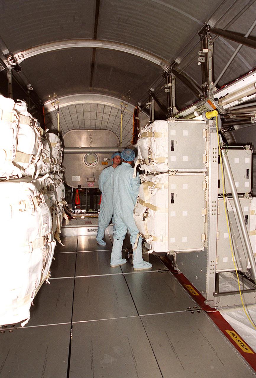 KENNEDY SPACE CENTER, FLA. -- Workers in the Space Station Processing Facility are able to enter the Multi-Purpose Logistics Module Leonardo to begin removing the contents. The MPLM has just returned from its maiden voyage to the International Space Station aboard Discovery on mission STS-102. It has brought back to KSC nearly a ton of trash and excess equipment from the Space Station. Leonardo is one of three MPLMs built by the Italian Space Agency to serve as “cargo vans” to the Station, carrying supplies and equipment. In the SSPF, Leonardo will be prepared for a future mission