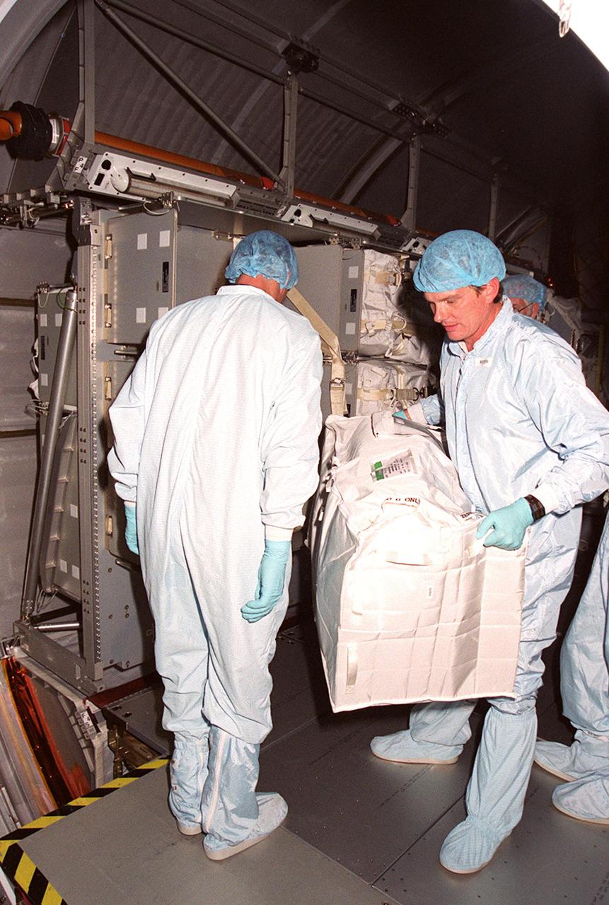 KENNEDY SPACE CENTER, FLA. -- Inside the Multi-Purpose Logistics Module Leonardo, which is in the Space Station Processing Facility, workers look over containers returned from the International Space Station on mission STS-102. The MPLM brought back to KSC nearly a ton of trash and excess equipment from the Space Station. Leonardo is one of three MPLMs built by the Italian Space Agency to serve as “cargo vans” to the Station, carrying supplies and equipment. In the SSPF, Leonardo will be prepared for a future mission