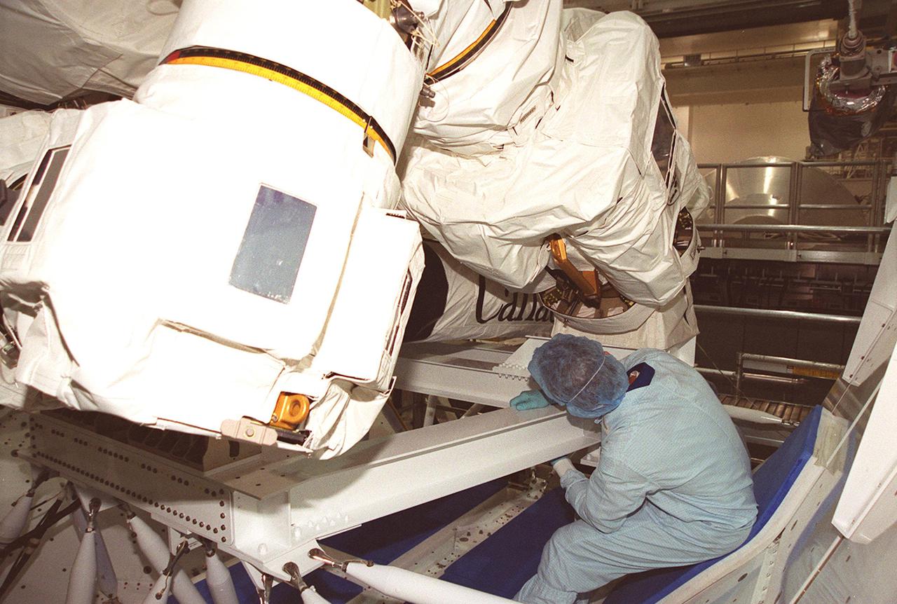 One of the STS-100 crew members looks at part of the Canadian robotic arm, SSRMS, which is on a workstand in the Space Station Processing Facility. The arm is 57.7 feet (17.6 meters) long when fully extended and has seven motorized joints. It is capable of handling large payloads and assisting with docking the Space Shuttle. The SSRMS is self-relocatable with a Latching End Effector, so it can be attached to complementary ports spread throughout the Station’s exterior surfaces. Mission STS-100 is scheduled to launch on Space Shuttle Endeavour April 19 at 2:41 p.m. EDT from Launch Pad 39A, KSC, with a crew of seven. The crew comprises Commander Kent V. Rominger, Pilot Jeffrey S. Ashby and Mission Specialists Chris A. Hadfield, Scott E. Parazynski, John L. Phillips, Umberto Guidoni and Yuri V. Lonchakov. Hadfield is with the Canadian Space Agency, Guidoni the European Space Agency and Lonchakov the Russian Space and Aviation Agency