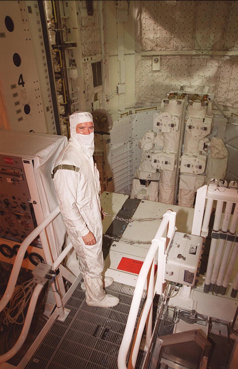STS-100 Mission Specialist Chris A. Hadfield, who is with the Canadian Space Agency, pauses for the photographer while looking over part of the mission payload, the Canadian robotic arm (SSRMS). The SSRMS is capable of handling large payloads and assisting with docking the Space Shuttle. It is crucial to the continued assembly of the International Space Station. Hadfield and the rest of the crew are at KSC to complete Terminal Countdown Demonstration Test activities that were postponed earlier. The TCDT includes emergency escape training, payload bay walkdown, and a simulated launch countdown. The primary payload also includes Multi-Purpose Logistics Module, Raffaello. Launch of Space Shuttle Endeavour on mission STS-100 is targeted for April 19 at 2:41 p.m. EDT from Launch Pad 39A