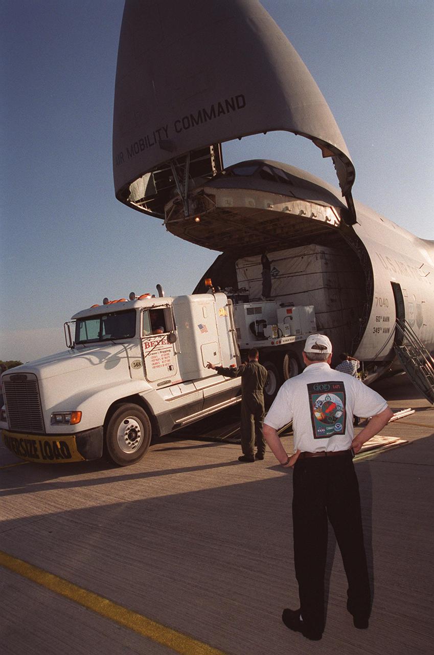 At the KSC Shuttle Landing Facility, a truck begins offloading the container with the GOES-M satellite from the yawning mouth of the C-5 aircraft. It will be transferred to Astrotech in Titusville, Fla., for final testing. The GOES-M (Geostationary Operational Environmental Satellite, I-M Series) provides weather imagery and quantitative sounding data used to support weather forecasting, severe storm tracking, and meteorological research. The satellite is scheduled to be launched on an Atlas-IIA booster, with a Centaur upper stage, July 12 from Launch Pad 36-A, Cape Canaveral Air Force Station