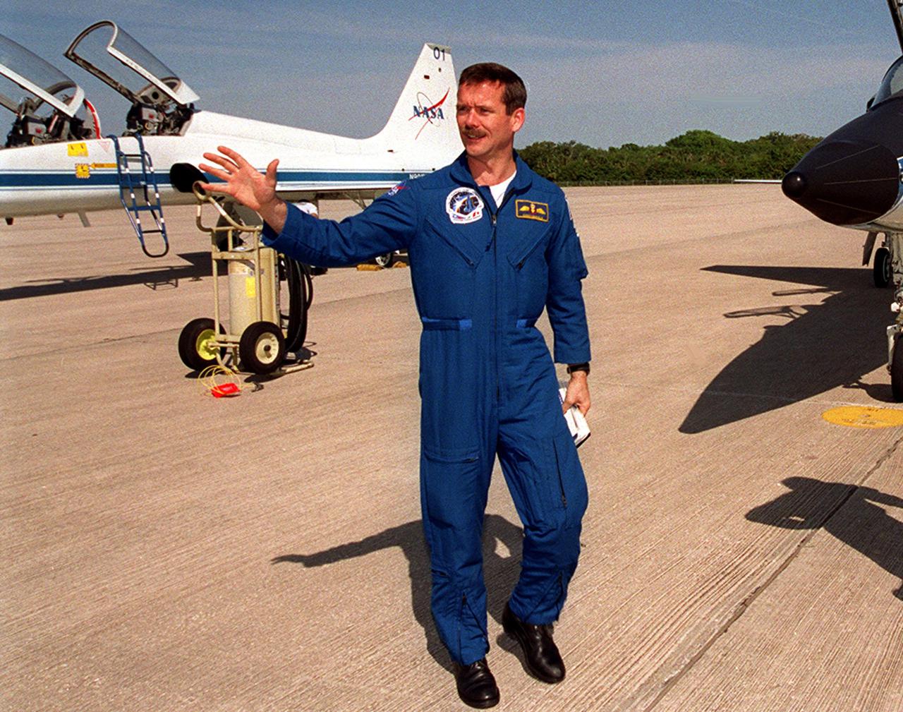 STS-100 Mission Specialist Chris A. Hadfield, who is with the Canadian Space Agency, waves to media after arriving at the KSC Shuttle Landing Facility for launch April 19. The 11-day mission to the International Space Station will deliver and integrate the Spacelab Logistics Pallet_Launch Deployment Assembly, which includes the Space Station Remote Manipulator system and the UHF Antenna, and the Multi-Purpose Logistics Module Raffaello. Liftoff on mission STS-100 is scheduled at 2:41 p.m. EDT April 19