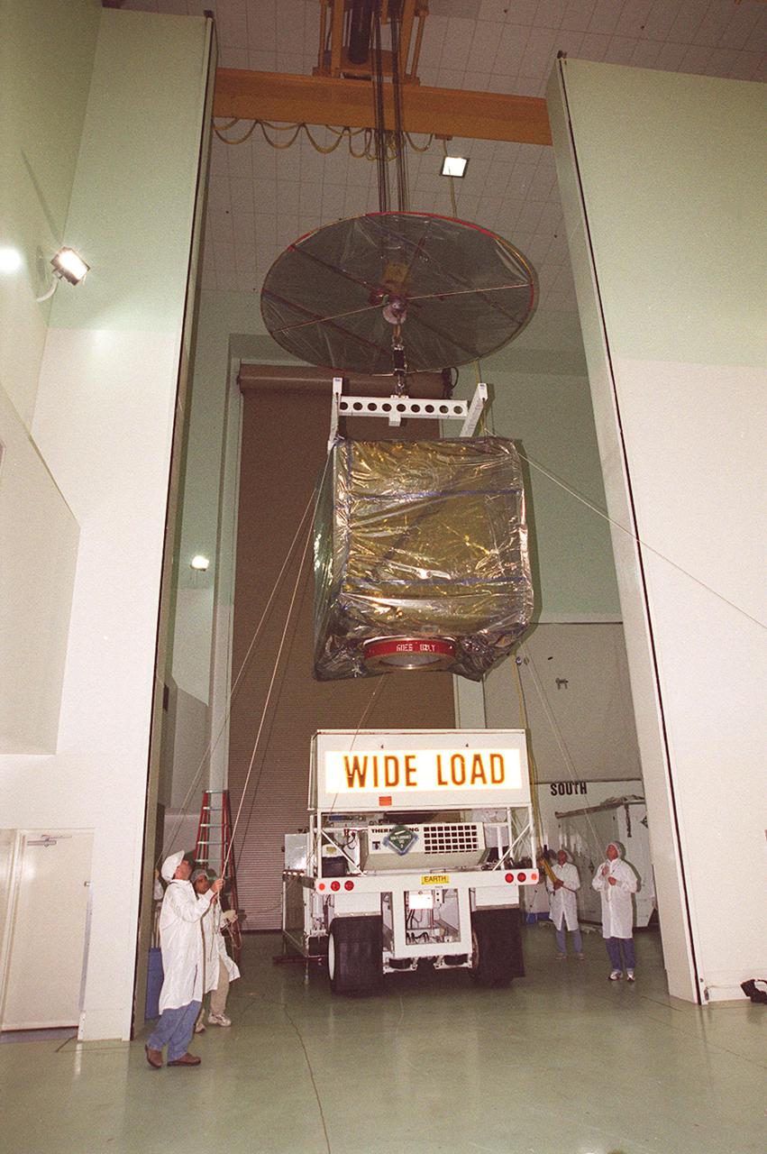 At Astrotech, Titusville, Fla., an overhead crane lifts the GOES-M (Geostationary Operational Environmental Satellite) from the transporter. The GOES-M provides weather imagery and quantitative sounding data used to support weather forecasting, severe storm tracking and meteorological research. The satellite will undergo testing at Astrotech before its scheduled launch July 12 on an Atlas-IIA booster, Centaur upper stage from Cape Canaveral Air Force Station