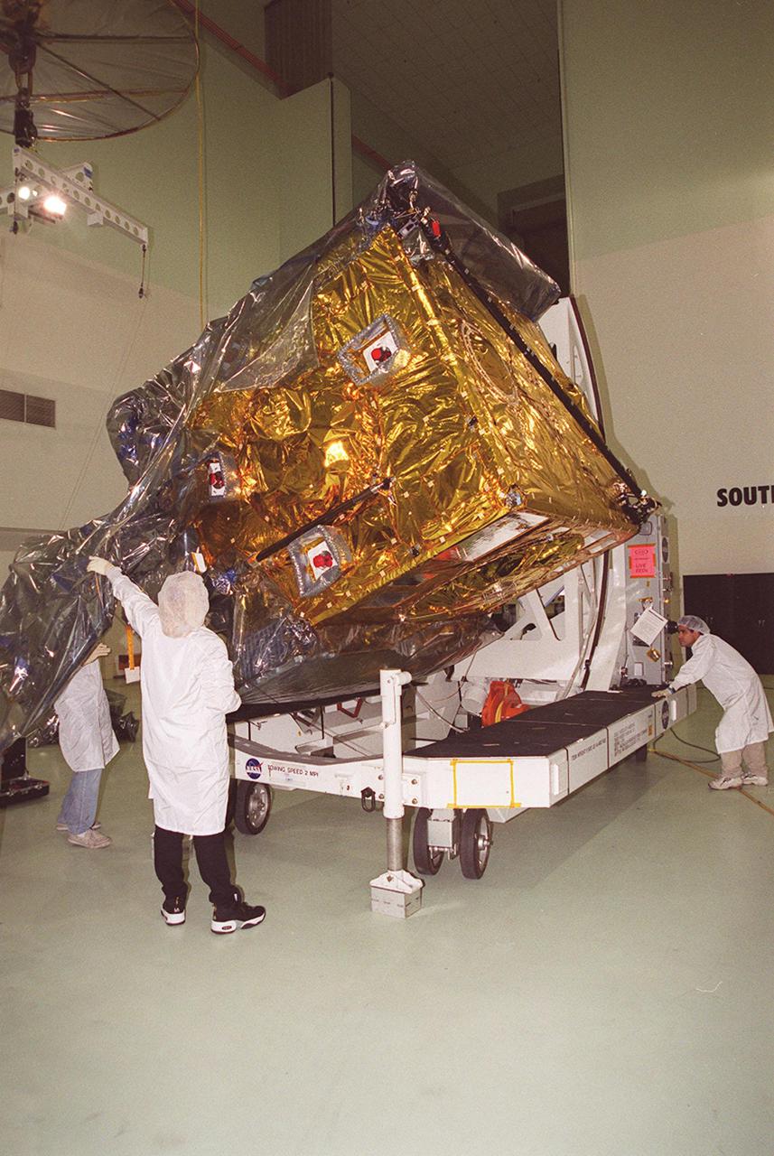 At Astrotech, Titusville, Fla., the GOES-M (Geostationary Operational Environmental Satellite) satellite is tilted on a workstand so that workers can remove the rest of the protective cover. The GOES-M provides weather imagery and quantitative sounding data used to support weather forecasting, severe storm tracking and meteorological research. The satellite will undergo testing at Astrotech before its scheduled launch July 12 on an Atlas-IIA booster, Centaur upper stage from Cape Canaveral Air Force Station