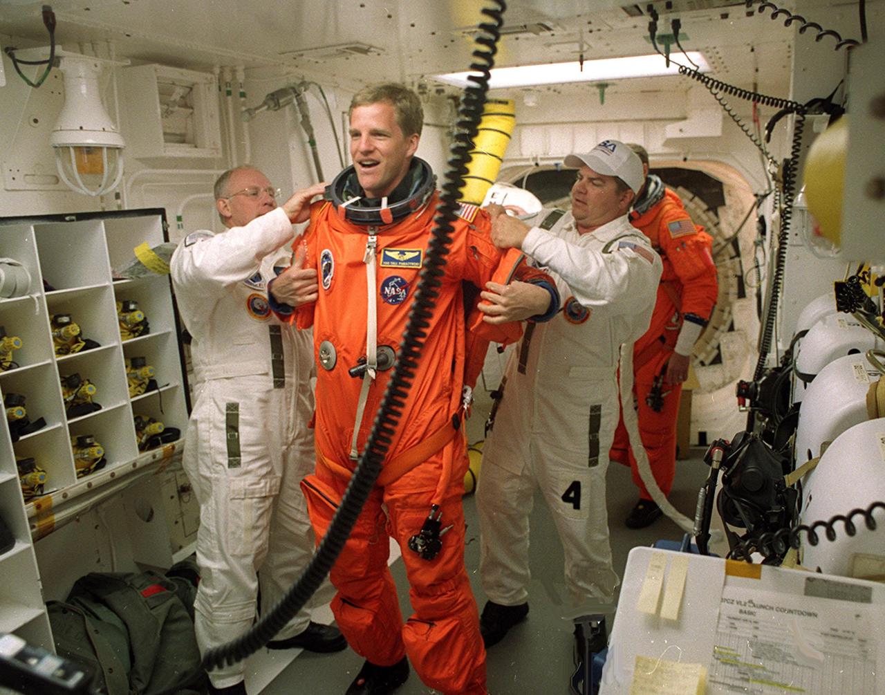 KENNEDY SPACE CENTER, FLA. -- In the White Room, STS-100 Mission Specialist Scott Parazynski is helped with his launch and entry suit by the closeout crew. The White Room is an environmental chamber at the end of the Orbiter Access Arm that provides entry into the orbiter on the launch pad. The mission will deliver and integrate the Spacelab Logistics Pallet_Launch Deployment Assembly, which includes the Canadian-built Space Station Remote Manipulator System and the UHF Antenna. Two spacewalks are planned for installation of the SSRMS, which will be performed by Mission Specialists Parazynski and Chris Hadfield, who is with the Canadian Space Agency. The mission is also the inaugural flight of Multi-Purpose Logistics Module Raffaello, carrying resupply stowage racks and resupply_return stowage platforms. Liftoff of Space Shuttle Endeavour on mission STS-100 is scheduled at 2:41 p.m. EDT April 19.