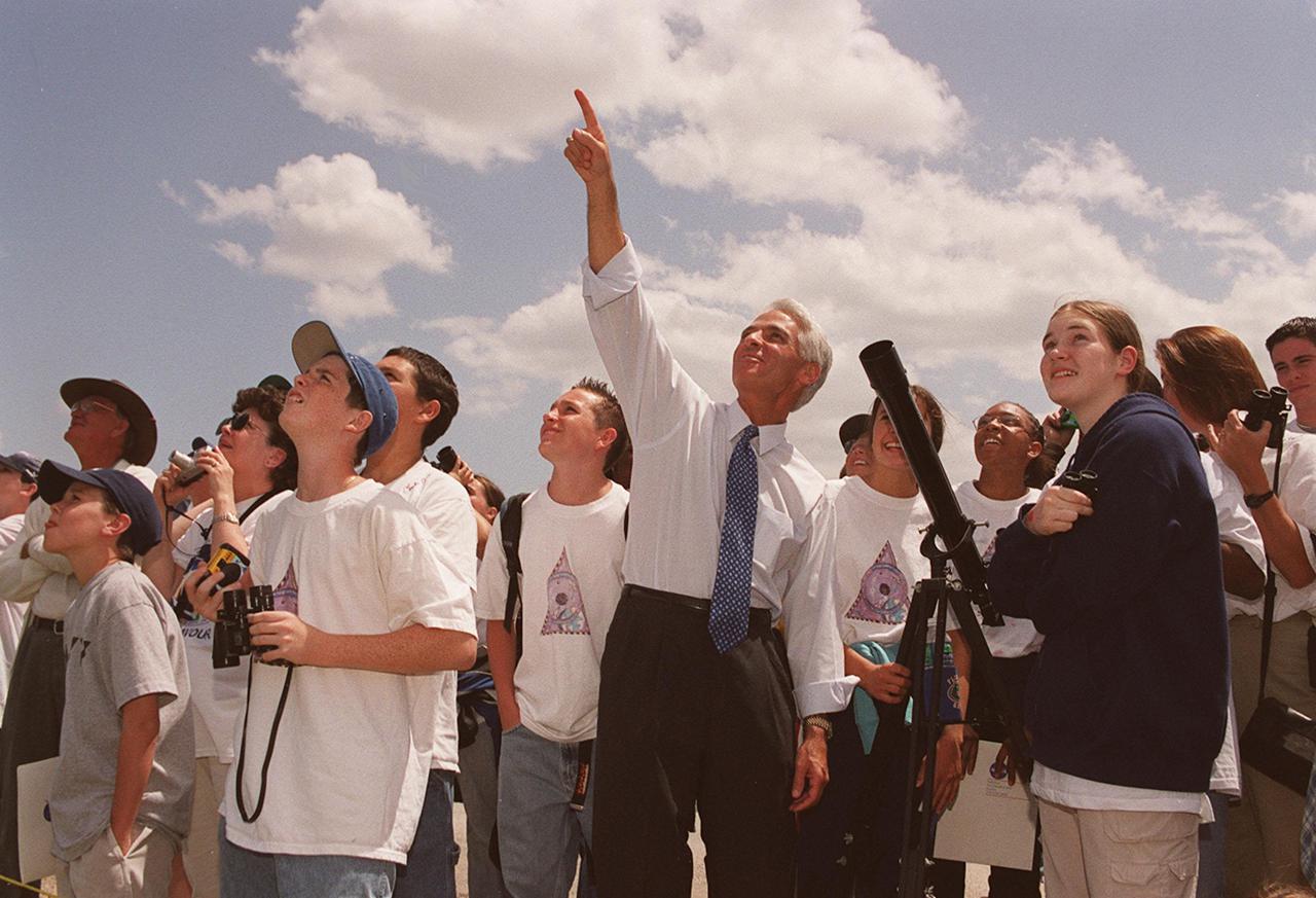 KENNEDY SPACE CENTER, FLA. -- Students from Ronald McNair Magnet School, Cocoa, Fla., follow the path of the Space Shuttle Endeavour after its launch on mission STS-100.  The State Education Commissioner Charlie Crist (center) points to rising Shuttle.  Crist was commemorating the 20th anniversary of Space Shuttle program with his visit to KSC for the launch
