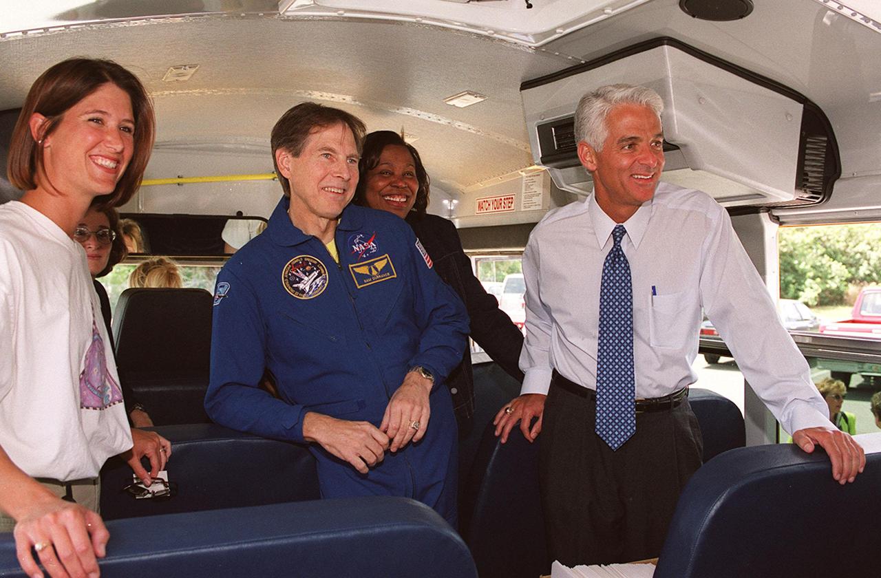 KENNEDY SPACE CENTER, FLA. -- State Education Commissioner Charlie Crist (right) talks to students from Ronald McNair Magnet School, Cocoa, Fla., on the school bus that brought them to KSC for the launch of Space Shuttle Endeavour on mission STS-100. Crist was commemorating the 20th anniversary of Space Shuttle program with his visit to KSC for the launch. In uniform (center) is astronaut Sam Durrance, who also accompanied the students. Chaperoning the students is teacher Nicole Waxberg (left)